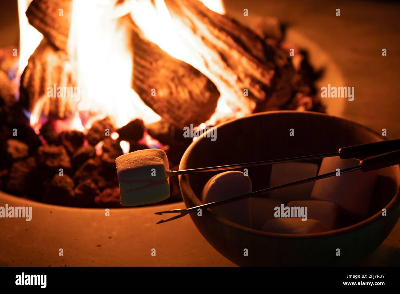 Rôtir le guimauve sur un feu de gaz tout en glampant Banque D'Images