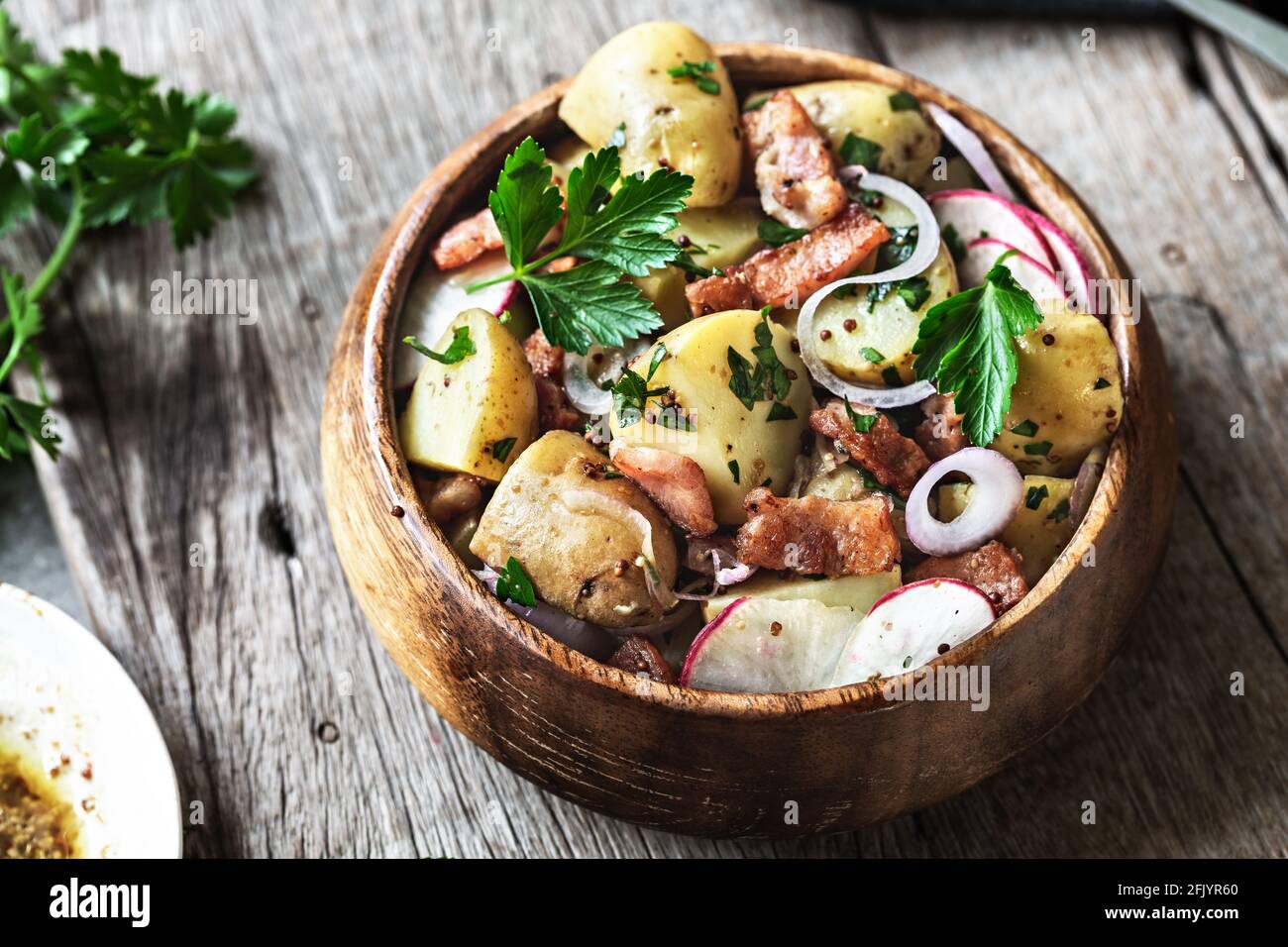 Pomme de terre au bacon, salade de radis dans un bol en bois Banque D'Images