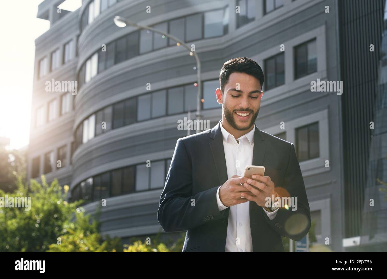 Photo de stock de haute qualité d'un homme d'affaires souriant regardant son téléphone Banque D'Images