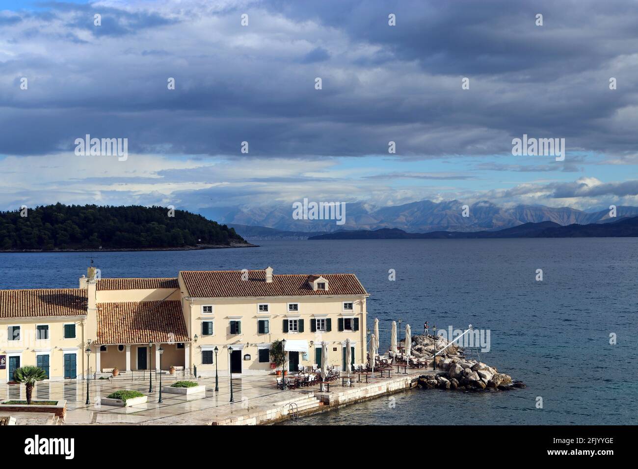 Vieille ville de Corfou, plage de Faliraki. En PLO restaurant et regarder au-delà de lui à l'île de Vidos et la Grèce continentale. Septembre, juste après une tempête. Banque D'Images