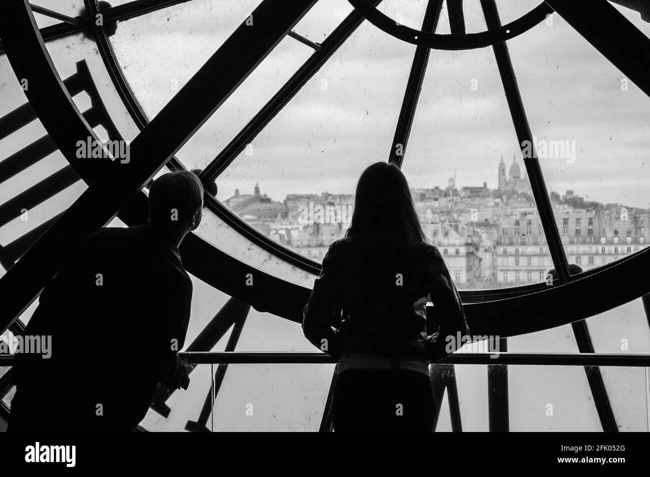 PARIS, FRANCE - 6 AVRIL 2014 : silhouettes d'un homme non identifié et d'une femme regardant à travers l'horloge avec des chiffres romains dans le musée d'Orsay on t Banque D'Images