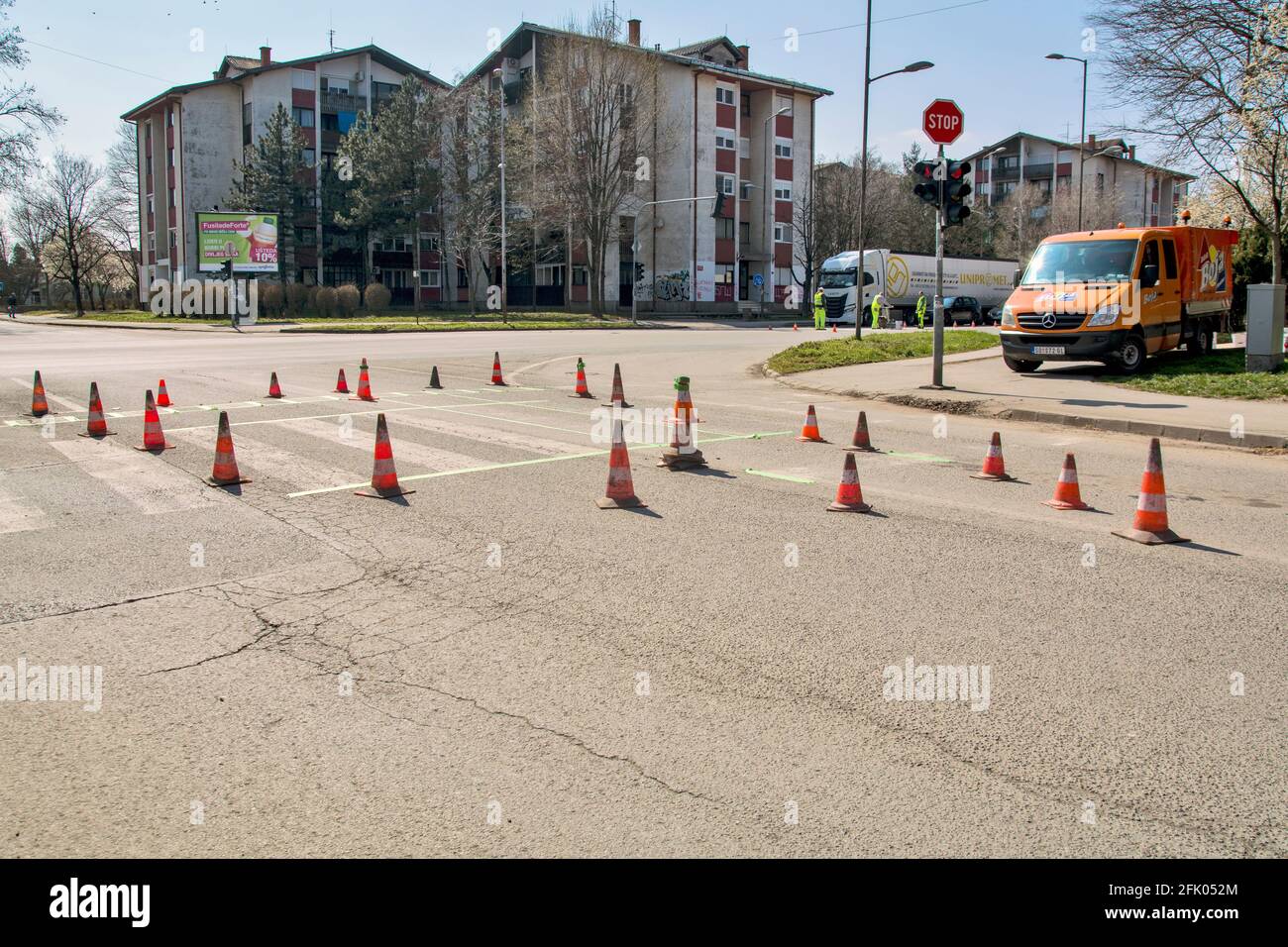 Zrenjanin, Serbie le 26 mars 2021. Les travailleurs d'une entreprise qui peint des passages piétons, communément appelés « zèbres », marquent et peignent sur l'asphalte. Banque D'Images