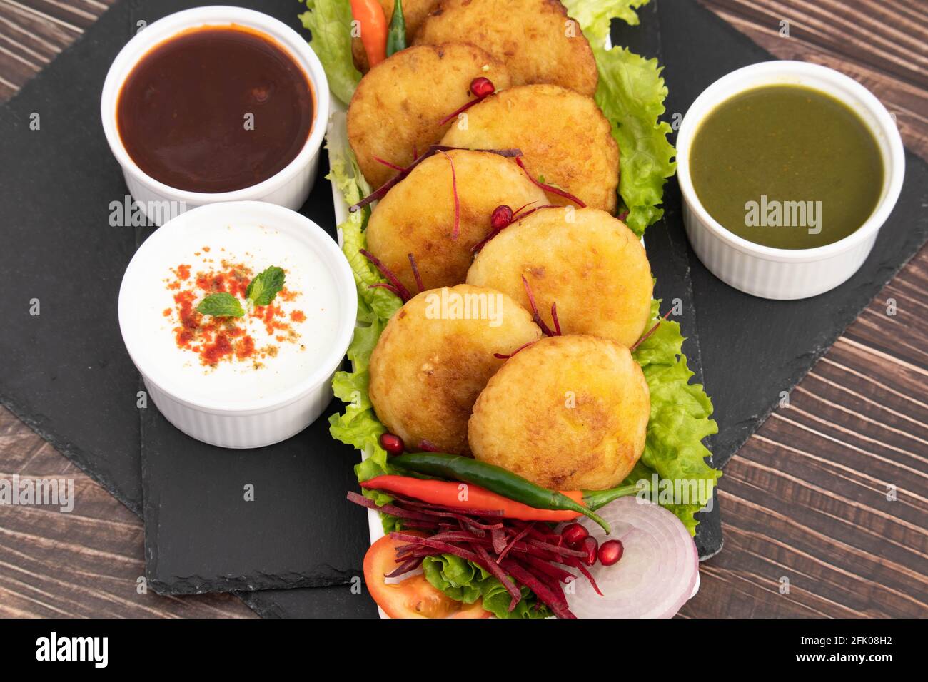 Plat décoré de délicieux Aloo Tikki également connu sous le nom d'Alu Ki Tikkia UNE purée de pommes de terre cuite assaisonnée ou des patties Servi avec Dhaniya Pudina GRE Banque D'Images