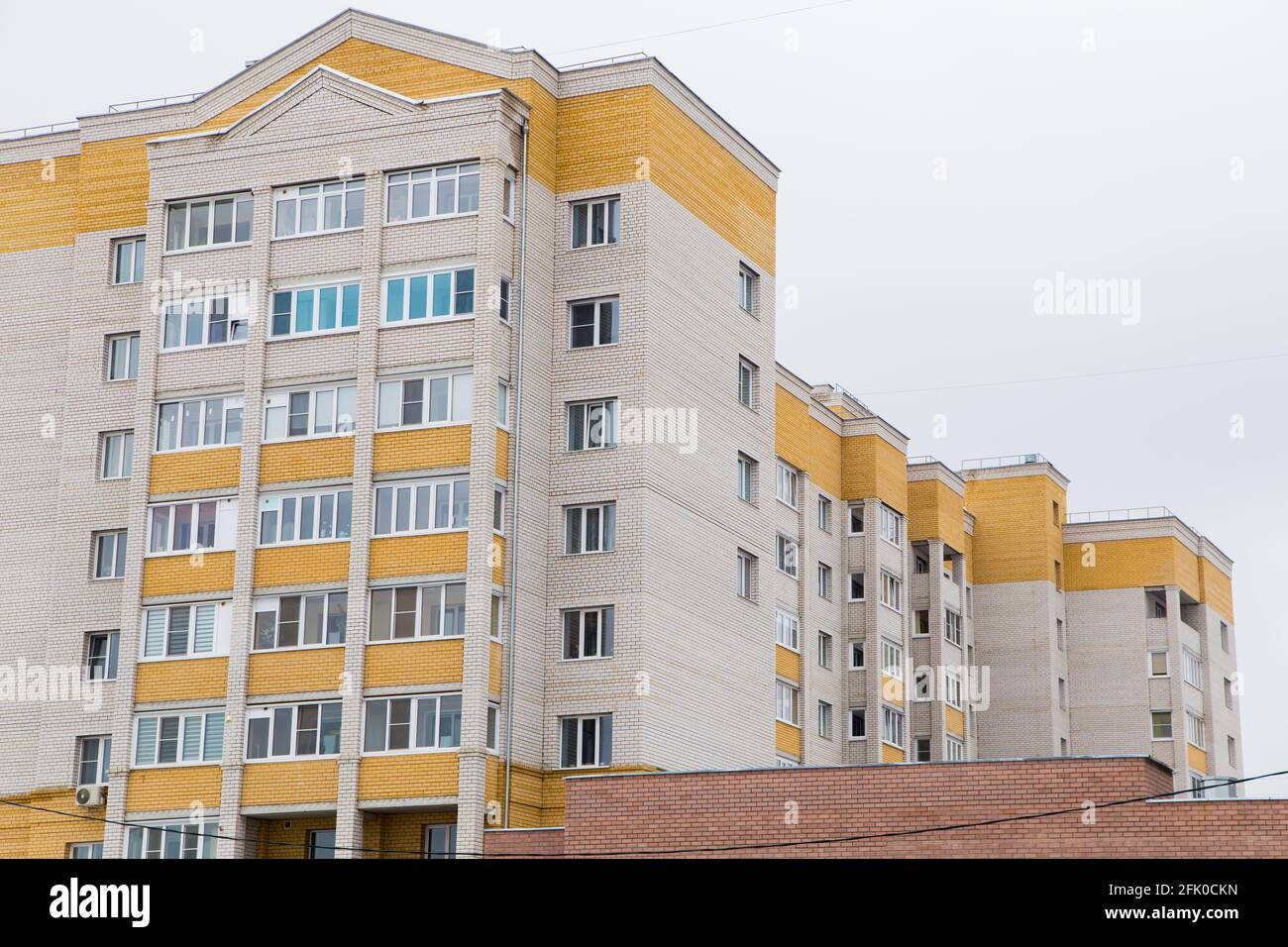 Immeubles résidentiels en briques de grande hauteur dans un quartier résidentiel de la ville. Sur fond de ciel gris. Nouveaux bâtiments modernes, façades de bâtiments. Concept immobilier et architecture urbaine. Banque D'Images