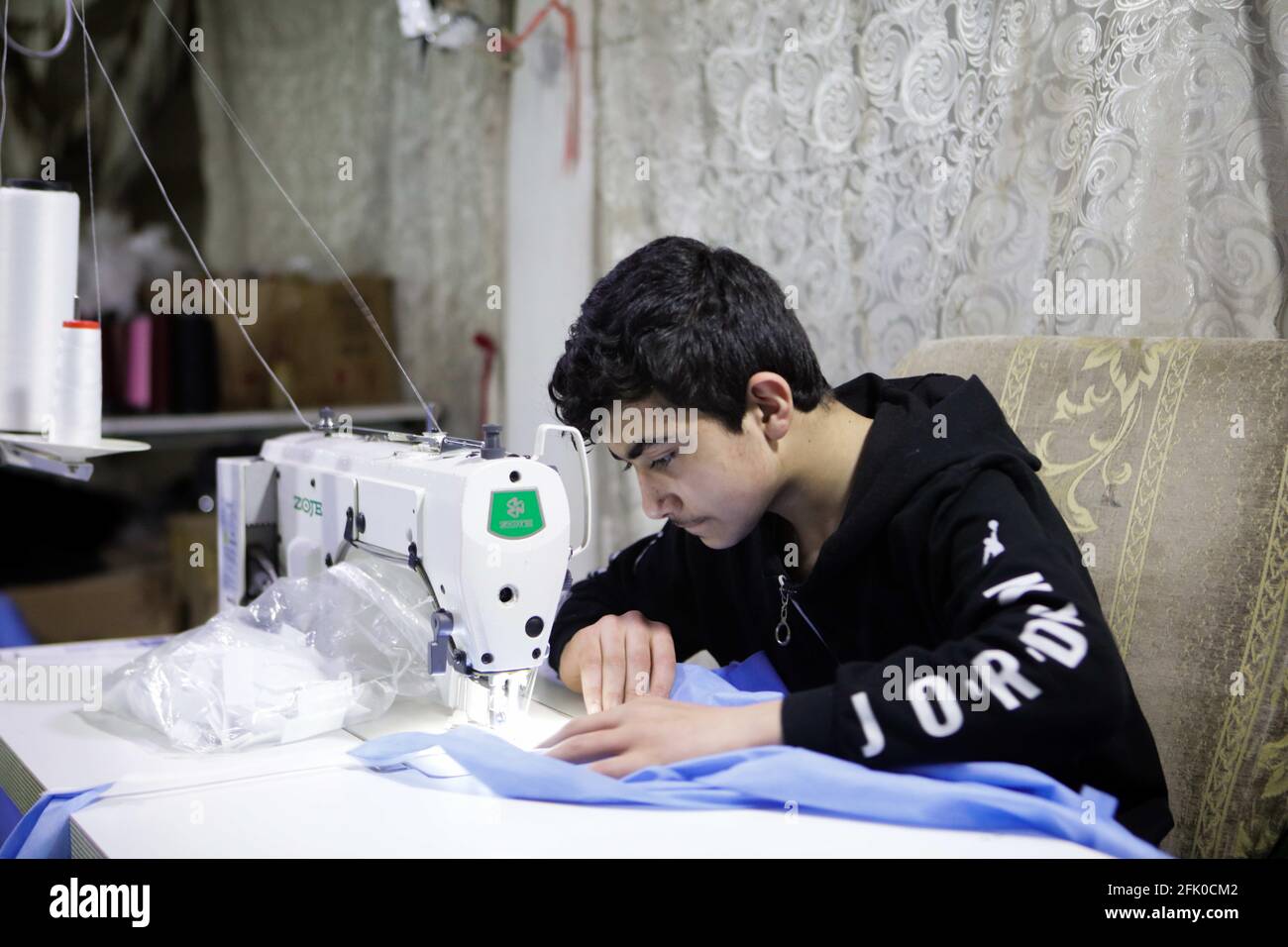 16 avril 2021, Gaziantep, Anatolie du Sud-est, Turquie : Gaziantep, Turquie.  Un garçon de 13 ans travaille avec son père à un atelier de couture dans la  ville turque de Gaziantep. L'atelier, qui produit des vêtements de haute  qualité et des blouses de ...