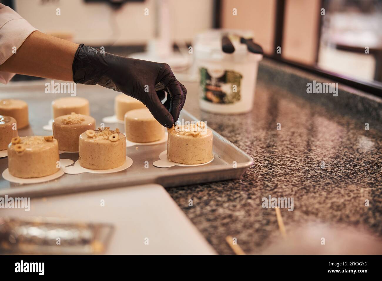 Chef pâtissier talentueux décorant des desserts faits main avec des noix Banque D'Images