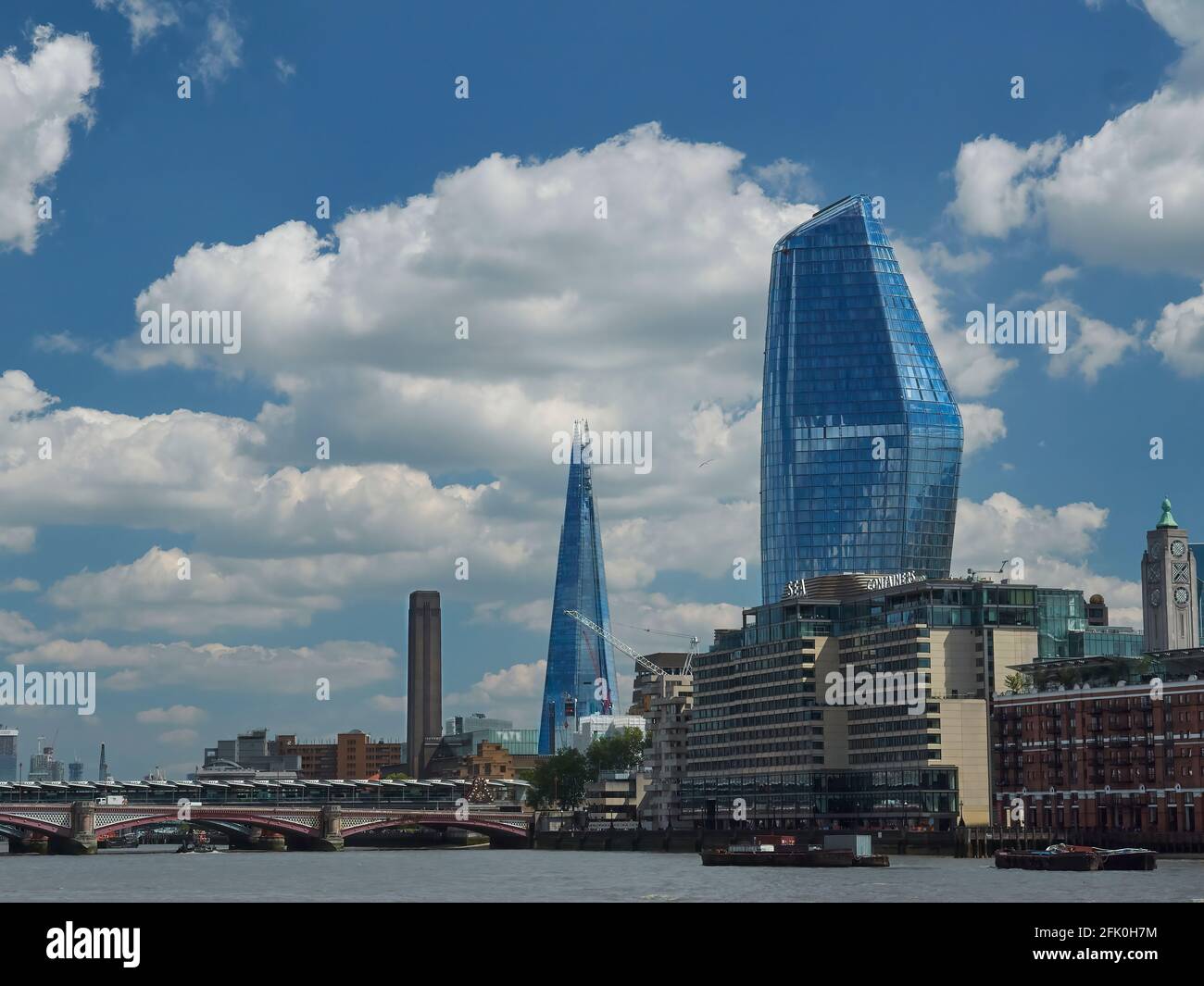 Vue sur les gratte-ciels (y compris le Shard et le Tate Modern) de l'autre côté de la Tamise depuis le Victoria Embankment, contre un ciel bleu vif en été. Banque D'Images