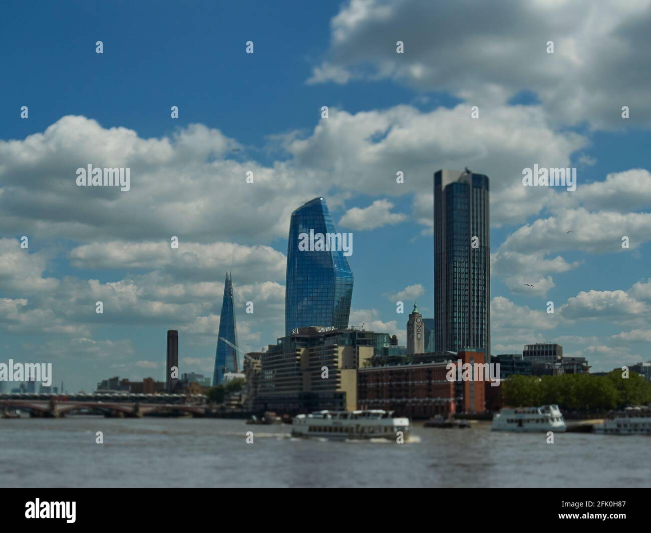 Vue sur les gratte-ciels (y compris le Shard et le Tate Modern) de l'autre côté de la Tamise depuis le Victoria Embankment, contre un ciel bleu vif en été. Banque D'Images