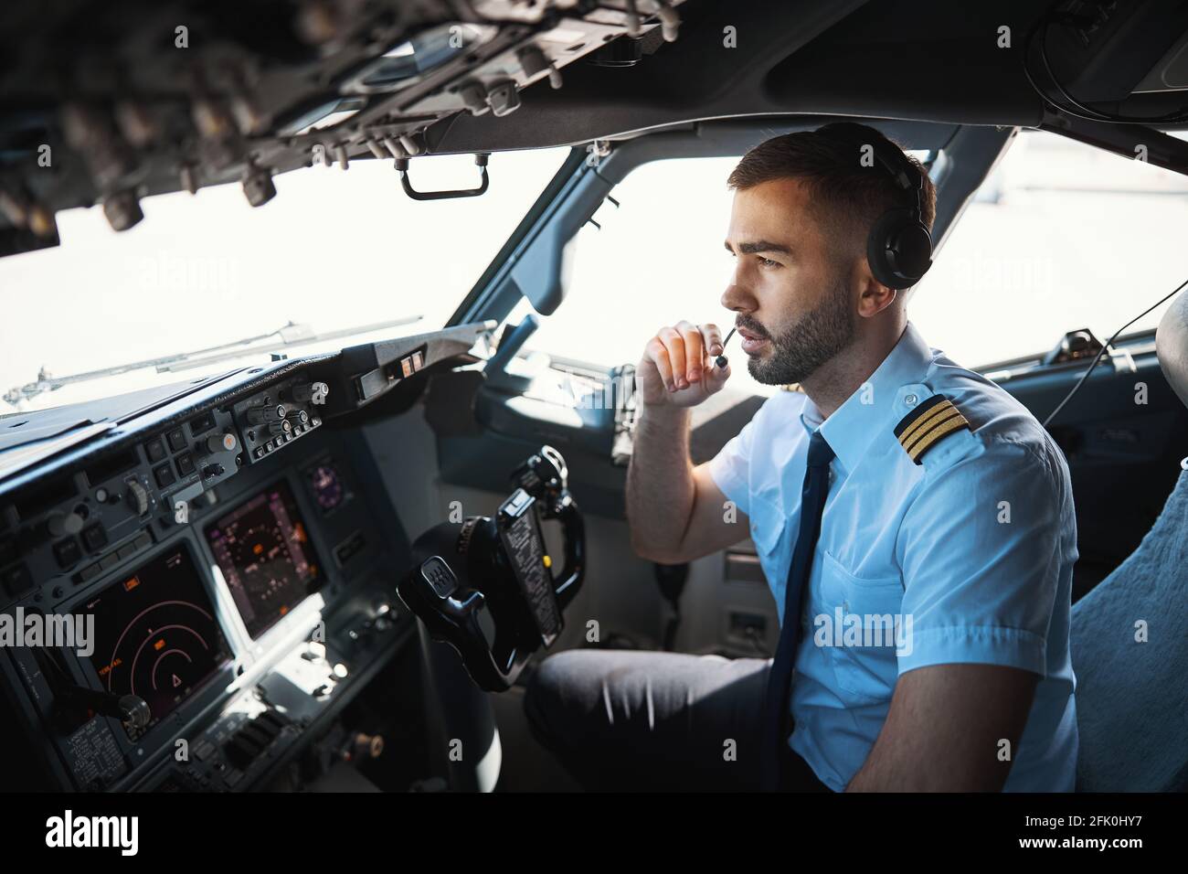 Un pilote sérieux parle avec ses collègues dans le microphone Photo Stock -  Alamy