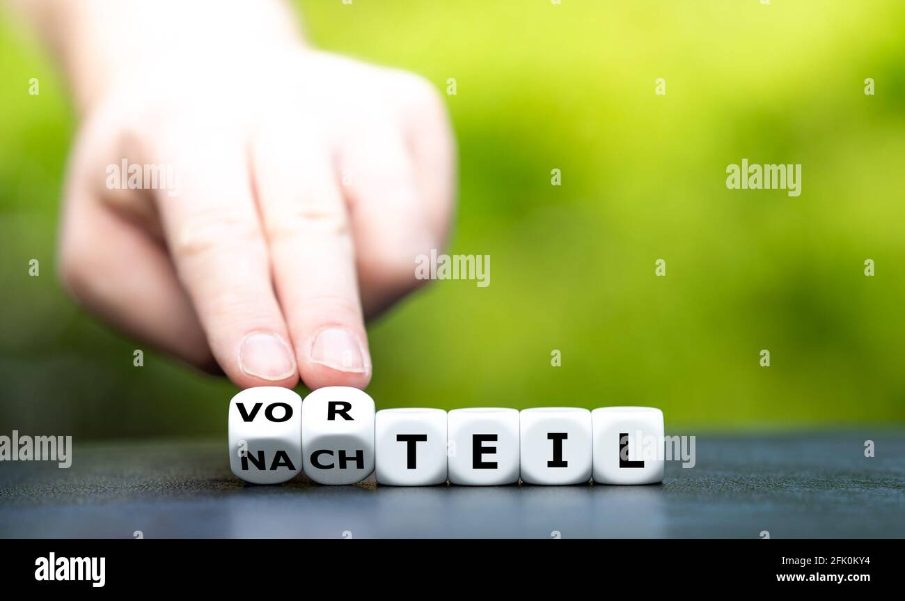 La main tourne les dés et change le mot allemand 'Nachteil' (désavantage) en 'Vorteil' (avantage). Banque D'Images