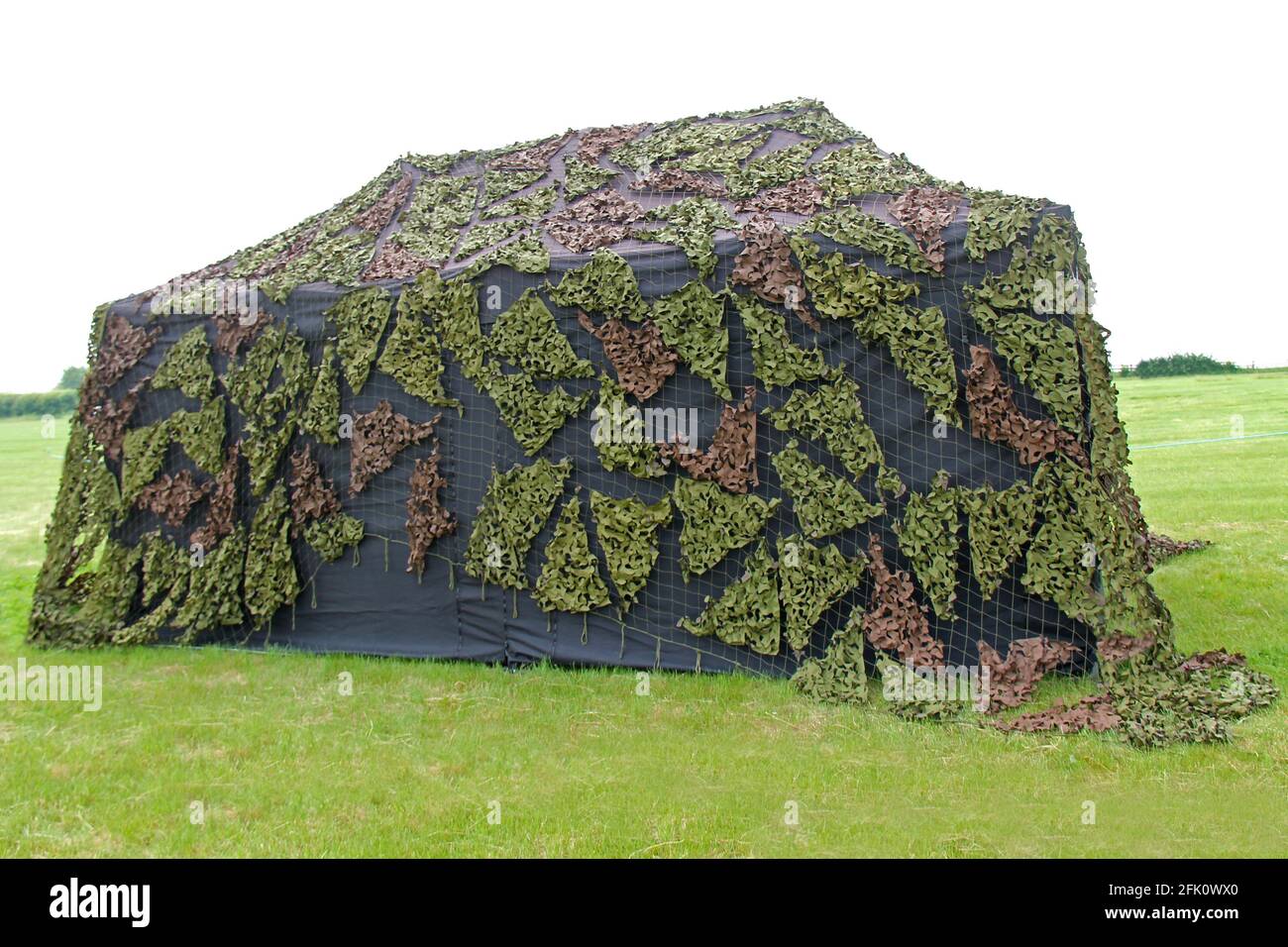 Une grande tente militaire avec une couverture de camouflage. Banque D'Images