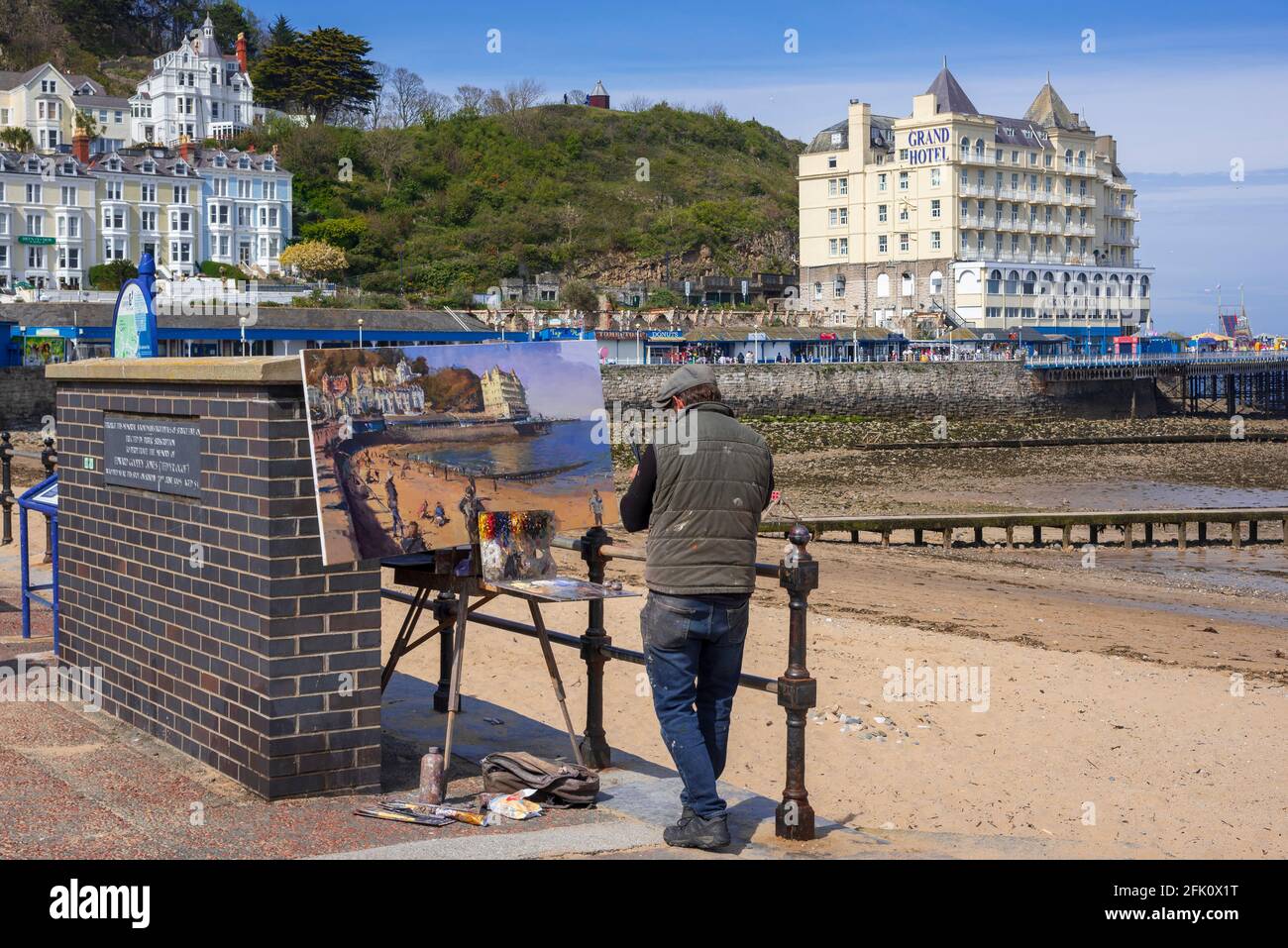 Les sites de Llandudno dans le nord du pays de Galles. Un artiste peint la scène en face du Grand Hôtel près de la jetée. Banque D'Images