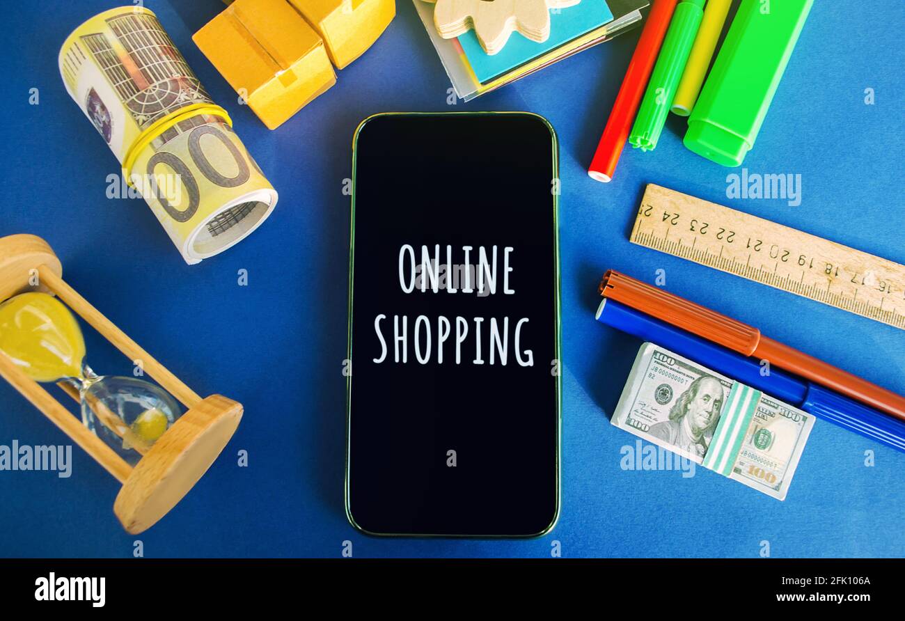 Téléphone avec le mot achats en ligne avec de l'argent, des boîtes et un sablier. Achat de biens et de services par Internet à l'aide d'un navigateur ou d'une application mobile Banque D'Images