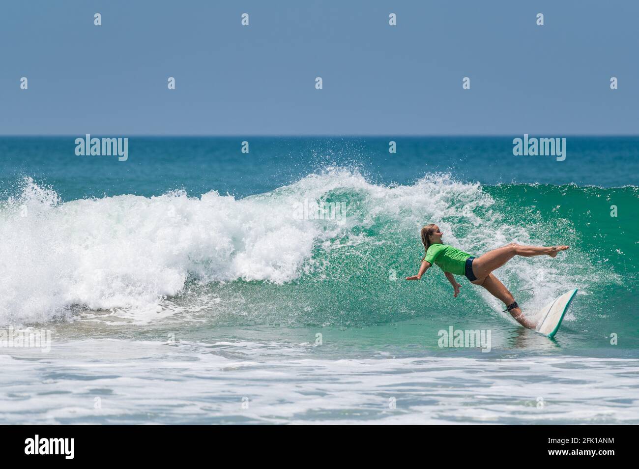 VARKALA, INDE - 14 mars 2020 : une femme de 26 ans qui tombe de son Longboard tout en surfant sur les côtes ouest du Kerala Banque D'Images