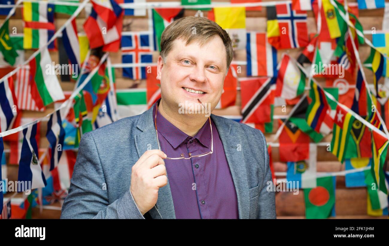 Homme adulte heureux avec des verres dans la main contre le arrière-plan du drapeau de pays Banque D'Images