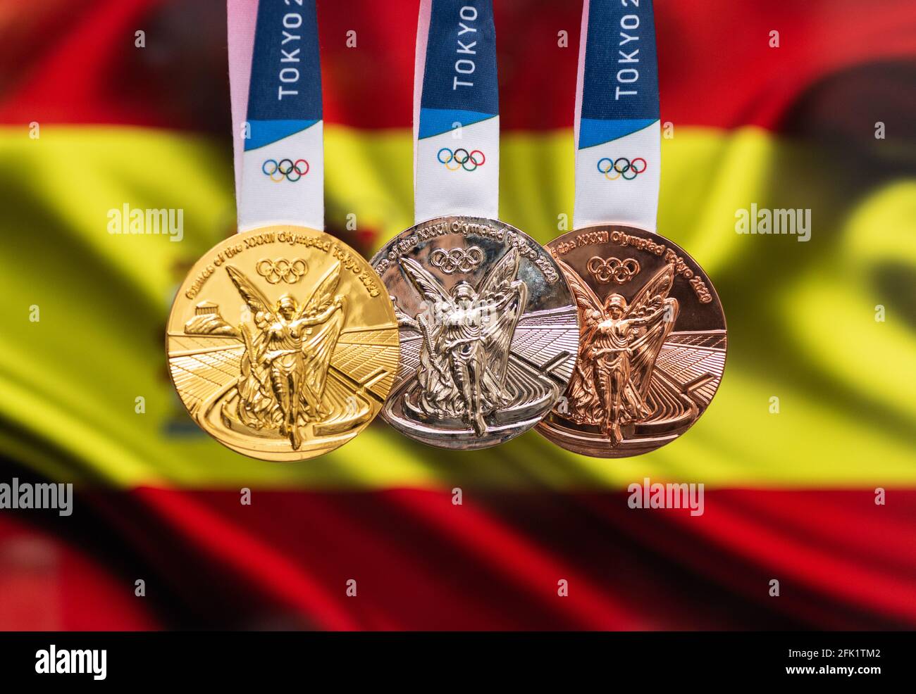 25 avril 2021 Tokyo, Japon. Médailles d'or, d'argent et de bronze des XXXII Jeux Olympiques d'été 2020 à Tokyo, sur fond de drapeau espagnol. Banque D'Images