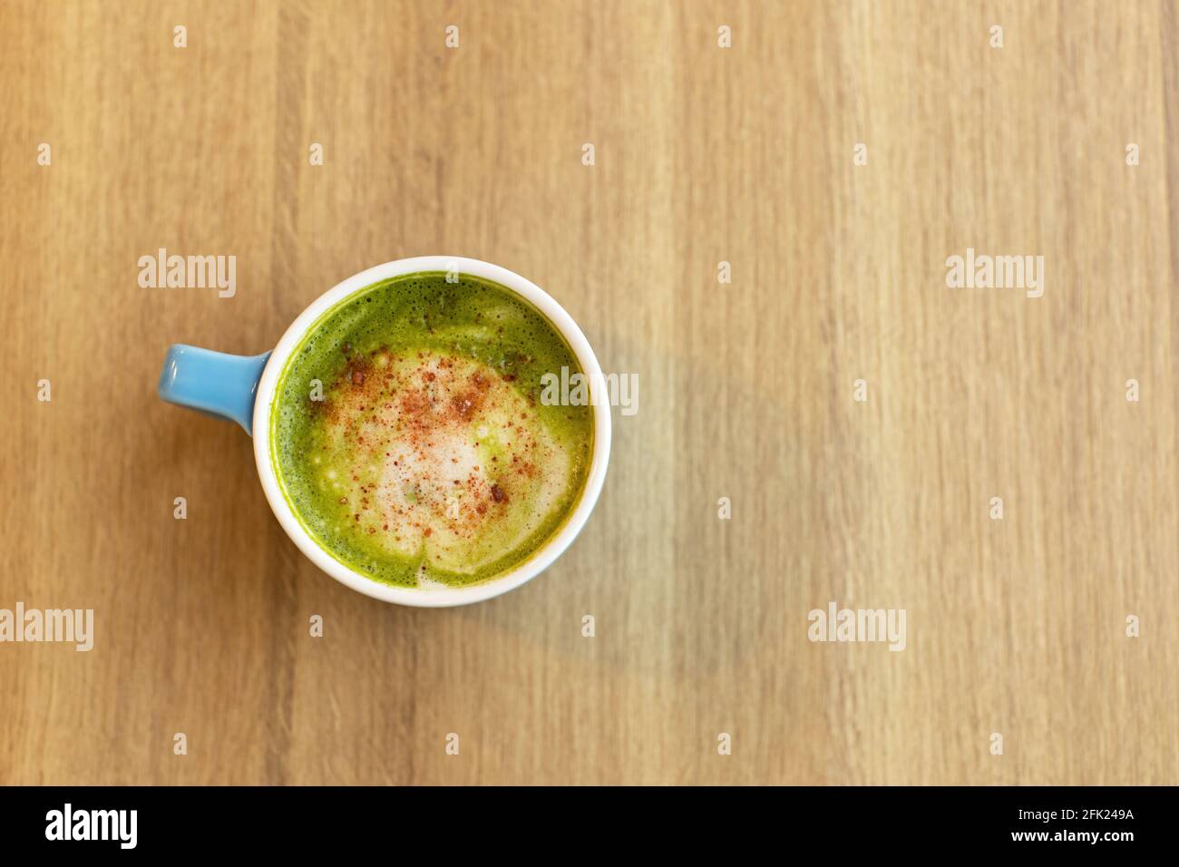 Tasse bleue avec thé vert matcha latte, avec fraises lyophilisées sur table en bois, espace de copie. Concept de nutrition saine, boissons avec légumes ou Banque D'Images