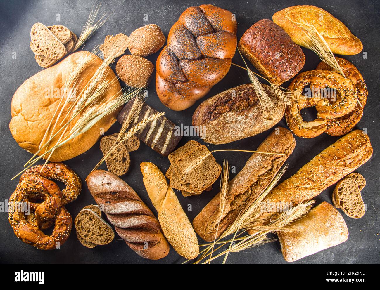 Assortiment de délicieux pains fraîchement cuits, sur fond de béton noir vue du dessus de l'espace de copie Banque D'Images