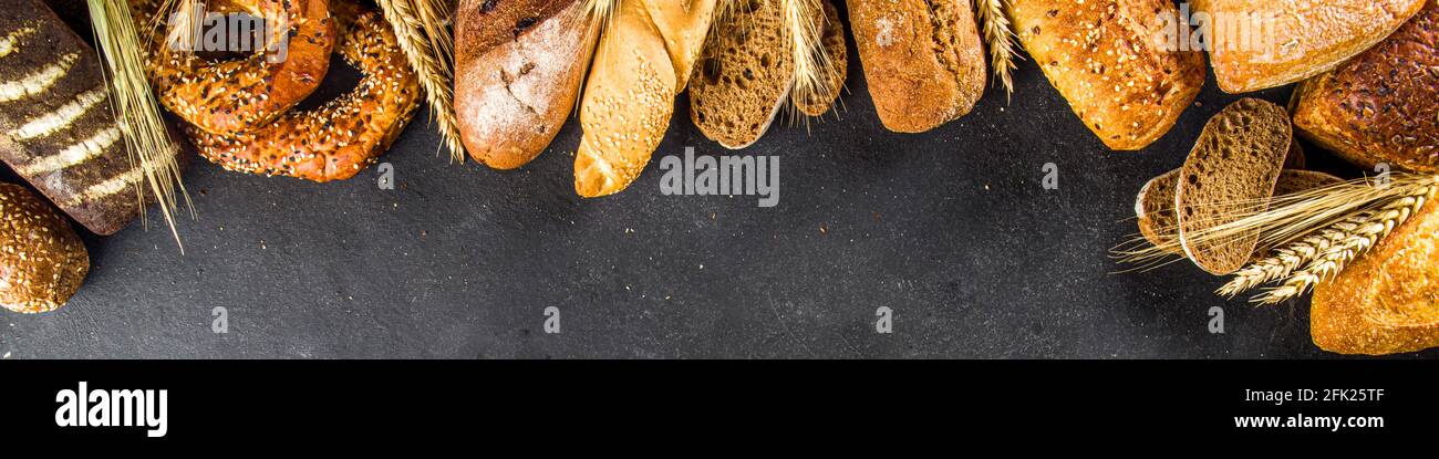 Assortiment de délicieux pains fraîchement cuits, sur fond de béton noir vue du dessus de l'espace de copie Banque D'Images
