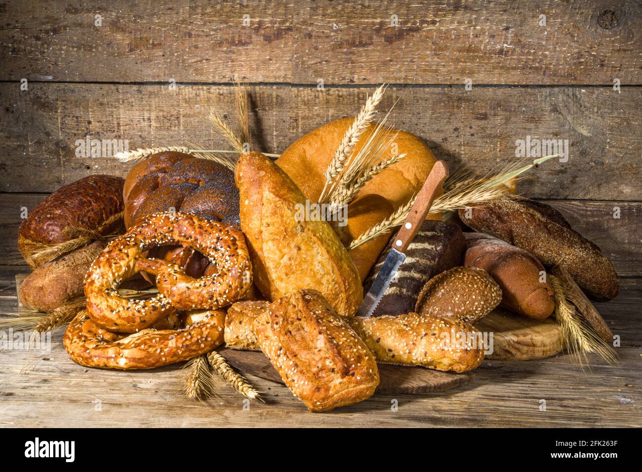 Assortiment de délicieux pains fraîchement sortis du four, sur fond de bois rustique copie espace Banque D'Images