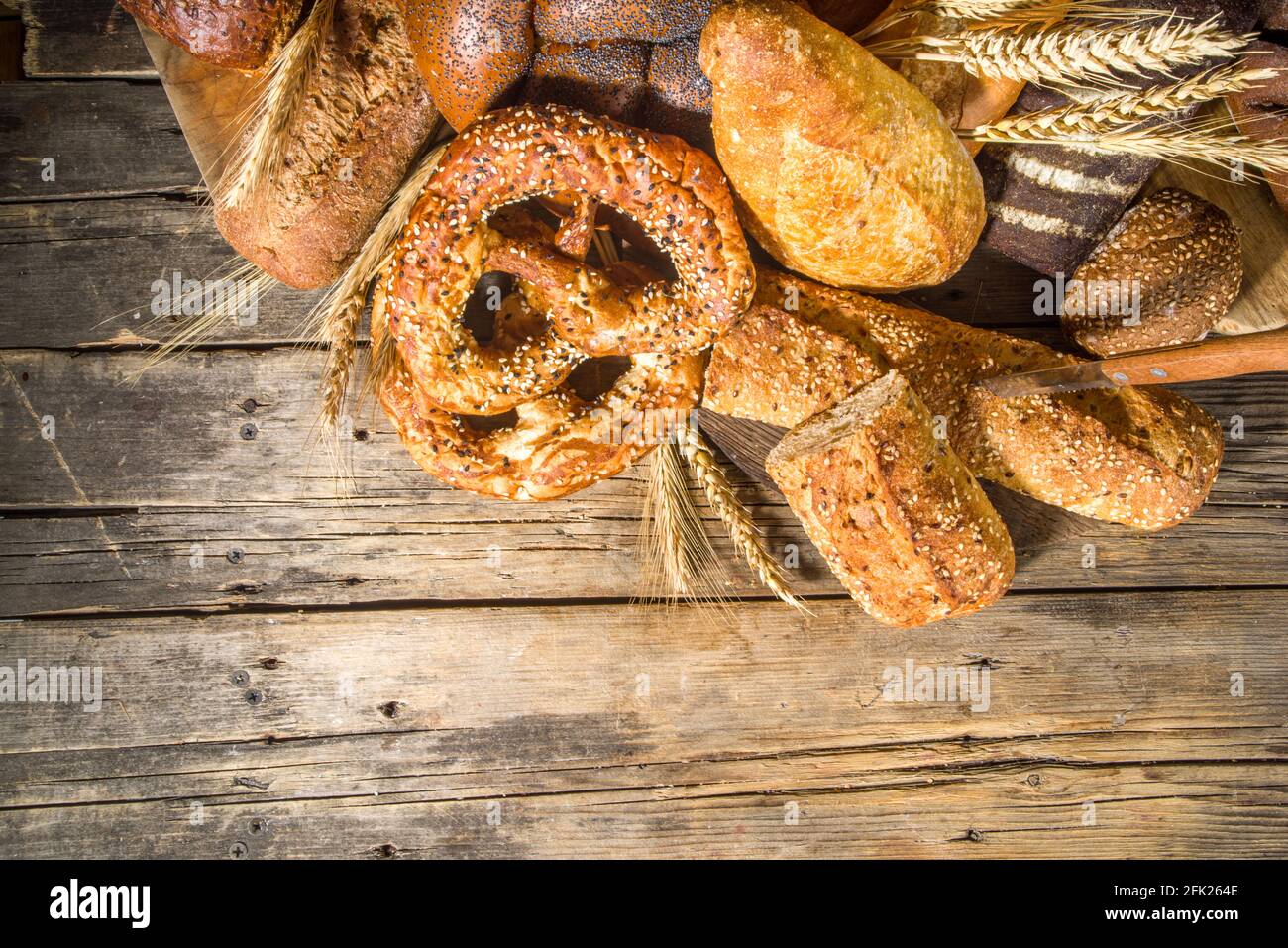 Assortiment de délicieux pains fraîchement sortis du four, sur fond de bois rustique copie espace Banque D'Images