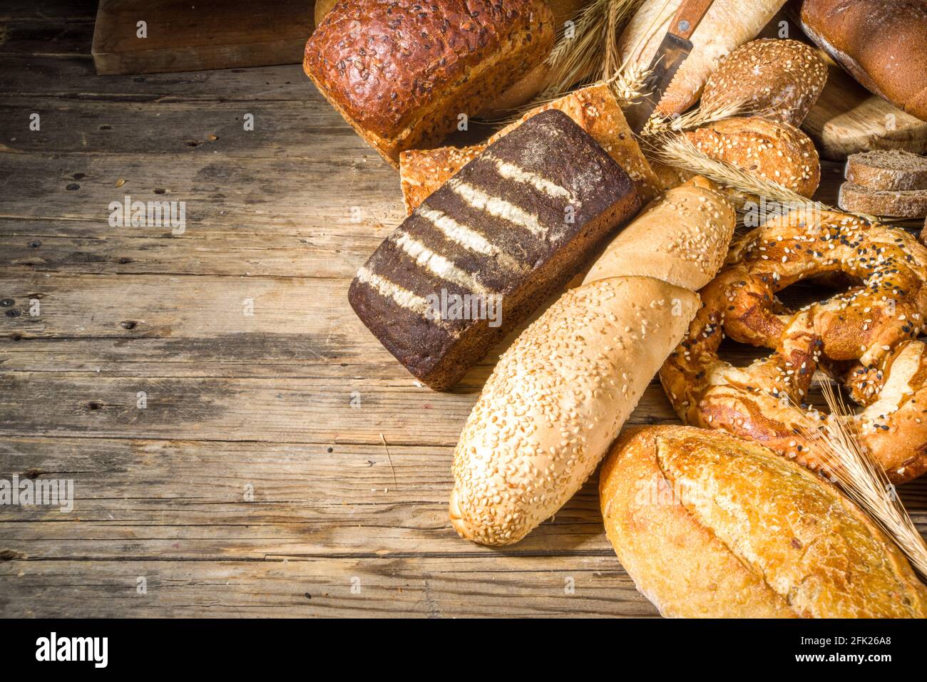 Assortiment de délicieux pains fraîchement sortis du four, sur fond de bois rustique copie espace Banque D'Images