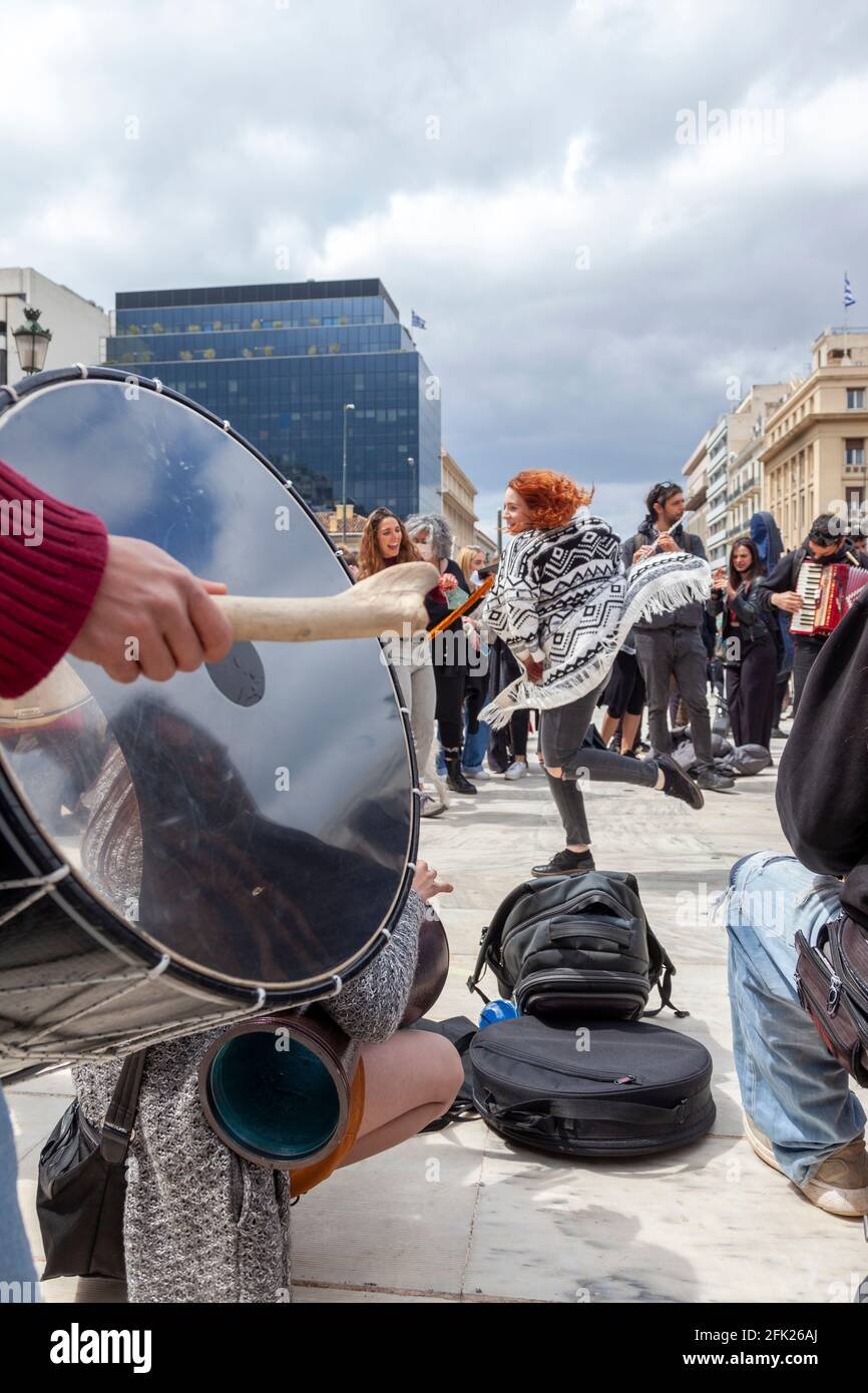 Une jeune fille dansant à des sons de percussion lors d'un événement musical de la manifestation des travailleurs d'art de soutien à Athènes, Grèce, en avril 2021. Banque D'Images