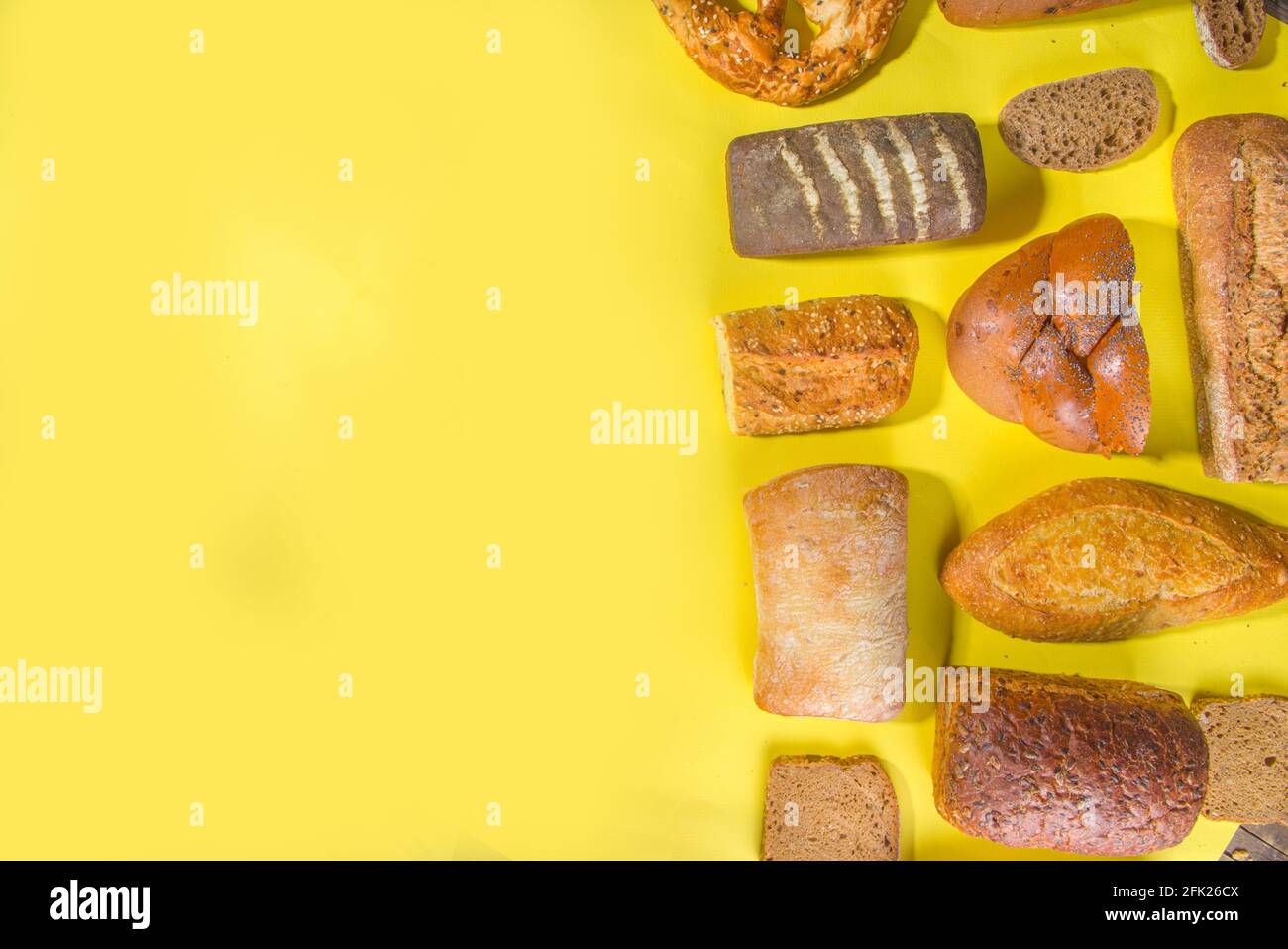 Assortiment de délicieux pains fraîchement cuits, sur fond lumineux et tendance, espace de copie avec vue de dessus, motif sur jaune Banque D'Images