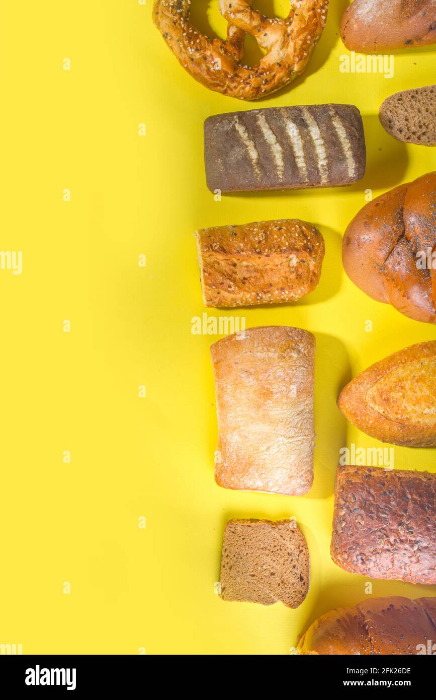 Assortiment de délicieux pains fraîchement cuits, sur fond lumineux et tendance, espace de copie avec vue de dessus, motif sur jaune Banque D'Images