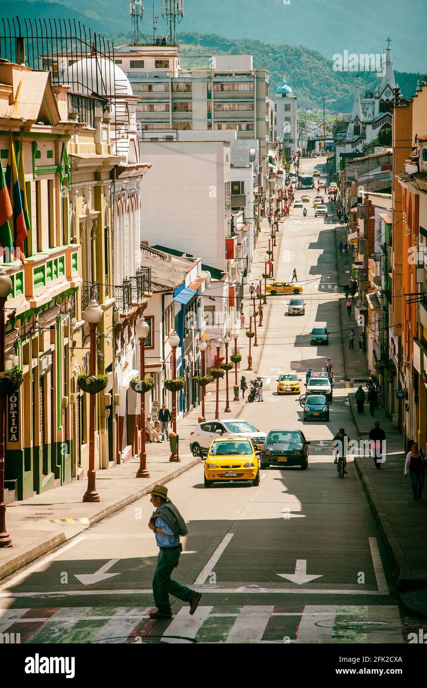 Homme dans un chapeau traversant la rue. Manizales, Caldas, Colombie. Banque D'Images