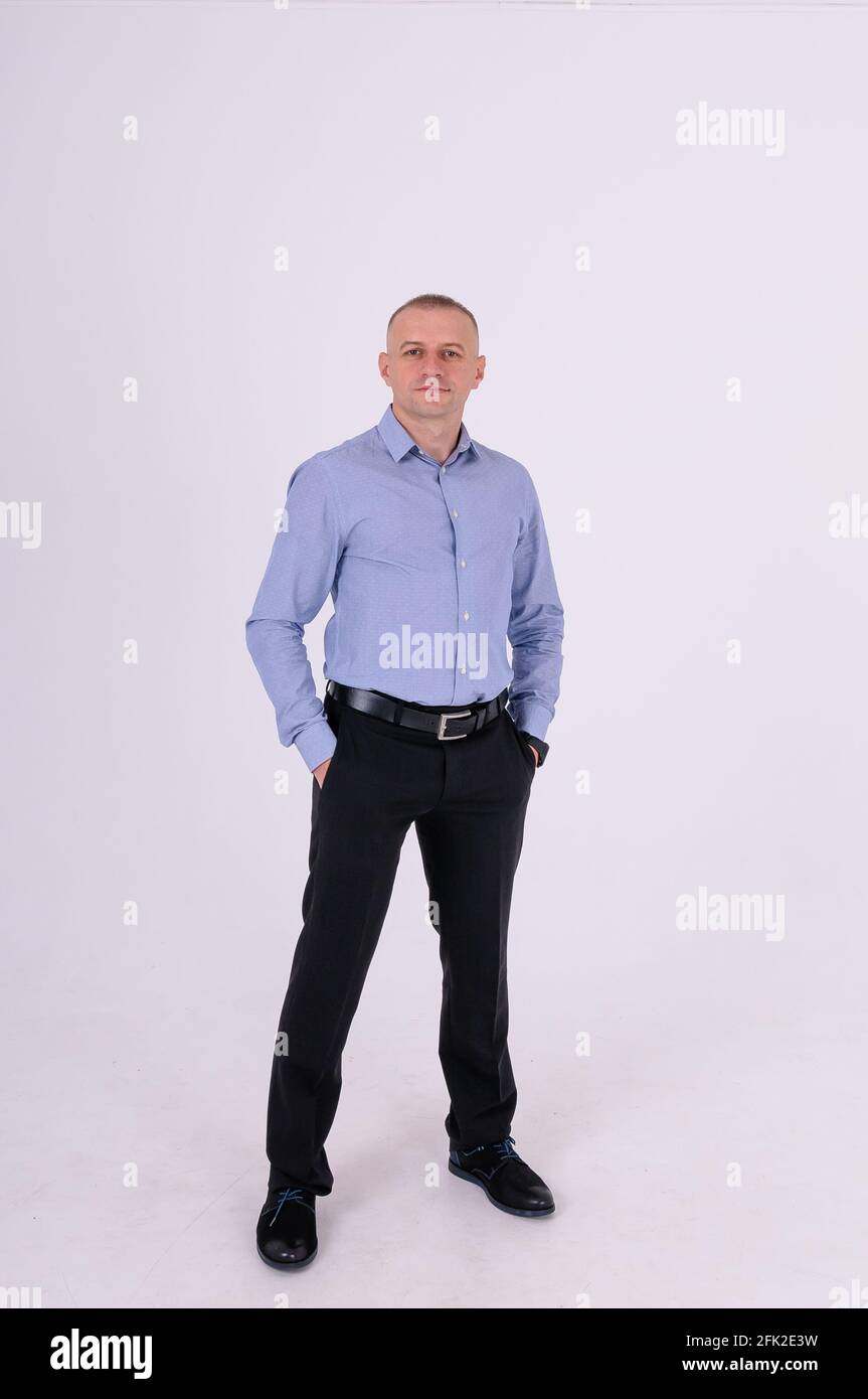 Homme en chemise bleue et pantalon noir sur fond blanc Banque D'Images
