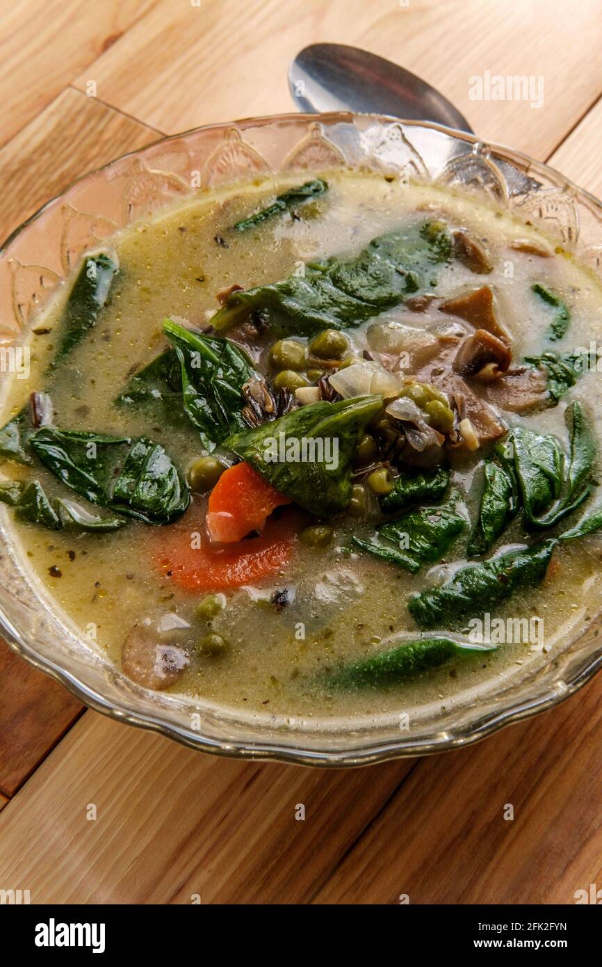Soupe crémeuse de champignons et de riz sauvage avec carottes aux épinards et pois verts Banque D'Images