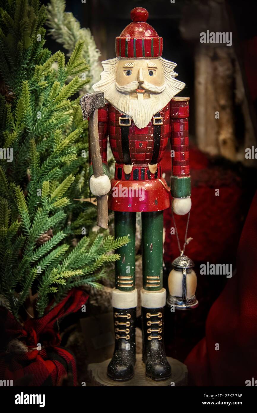 Casse-noisette de Noël en bois de Woodsman entouré de hache et de latern arbres et bois et carreaux rouges Banque D'Images