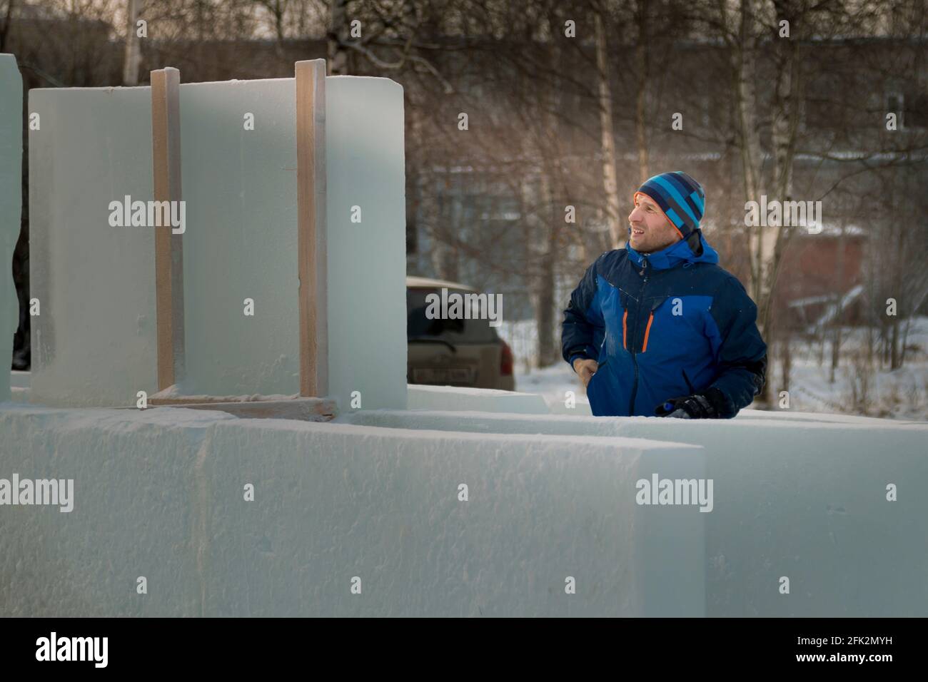 Portrait d'un assembleur de travail dans une veste bleue et chapeau bleu tricoté près d'un panneau de glace Banque D'Images