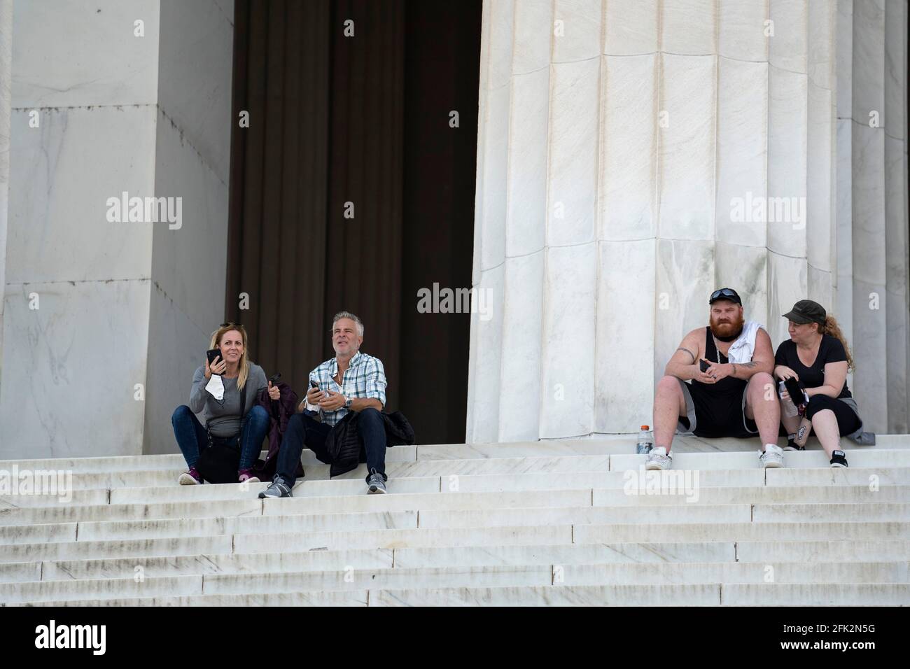 Washington, États-Unis. 27 avril 2021. Les gens sont assis sur les marches du Lincoln Memorial à Washington, DC, aux États-Unis, le 27 avril 2021. Les Centers for Disease Control and Prevention (CDC) des États-Unis ont dévoilé mardi de nouvelles lignes directrices pour les Américains entièrement vaccinés, y compris des activités qu'ils peuvent reprendre en toute sécurité sans porter de masques. Credit: Liu Jie/Xinhua/Alay Live News Banque D'Images