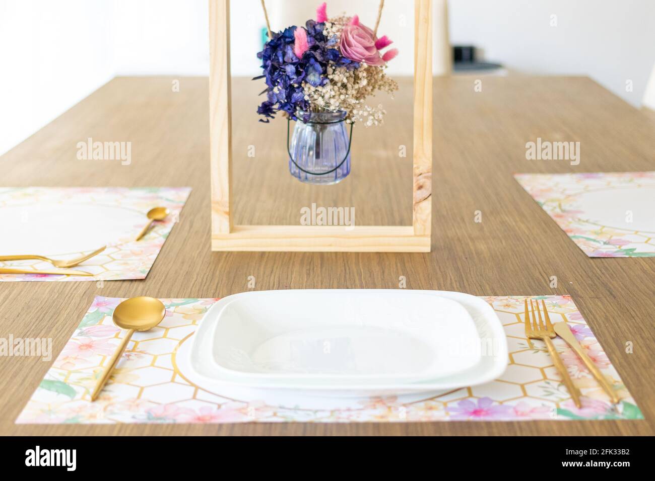 Assiette avec ustensiles, sur la table décorée d'un petit arrangement de fleurs Banque D'Images