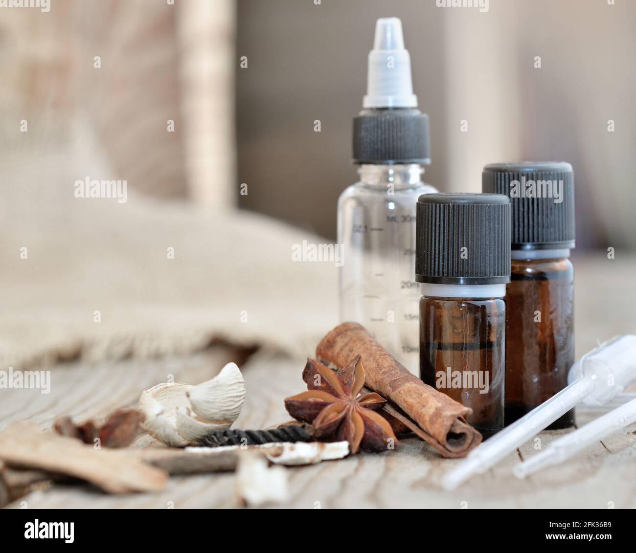 bouteilles d'huile essentielle et d'épices sur une table en bois avec pipette pour extraire l'essence Banque D'Images