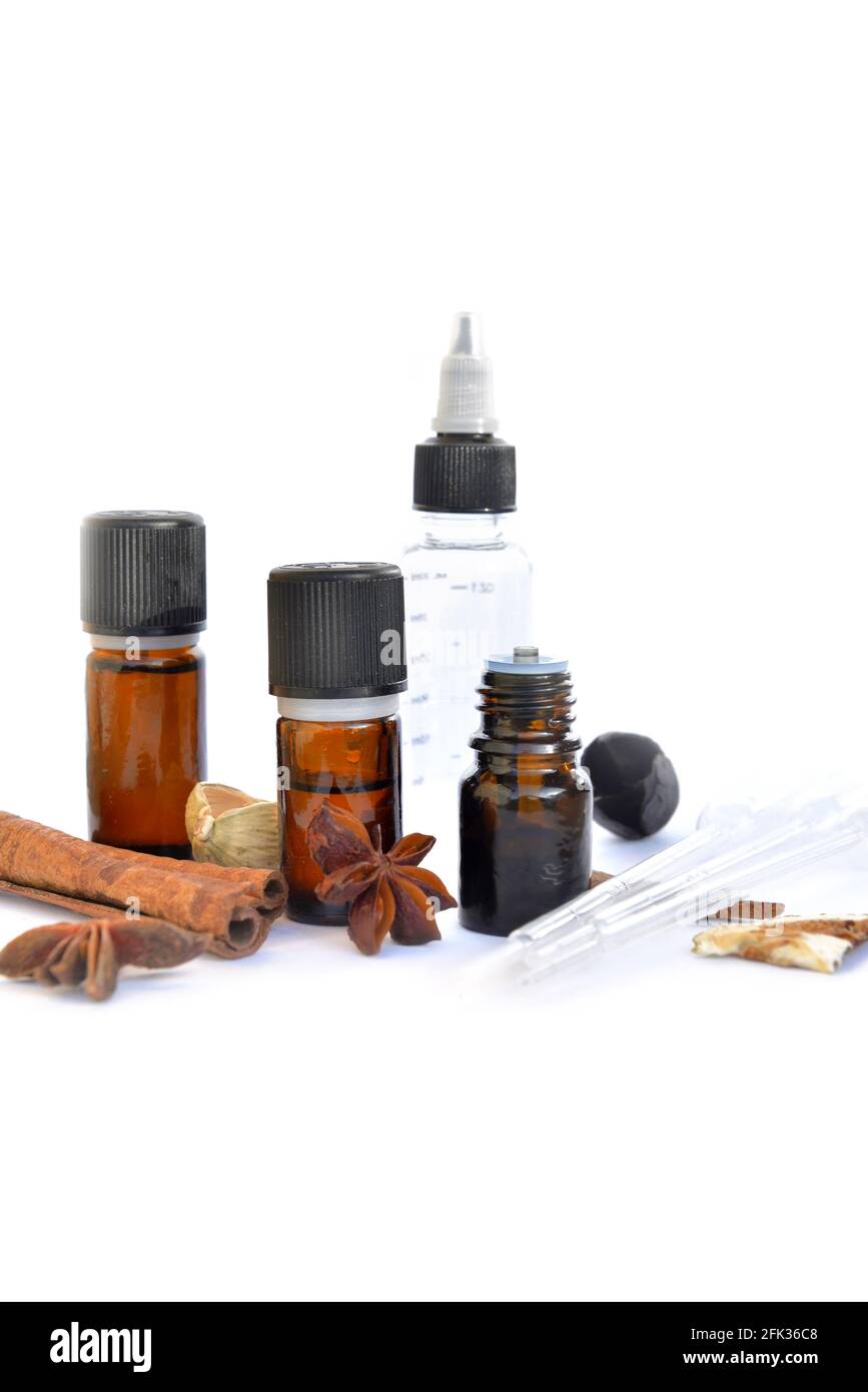bouteille d'huile essentielle et de cannelle et d'anis sur un fond blanc avec pipette pour extraire l'essence Banque D'Images