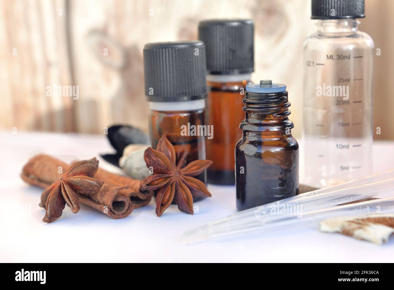 bouteilles d'huile essentielle et de cannelle et d'anis sur un table blanche avec pipette pour extraire l'essence Banque D'Images