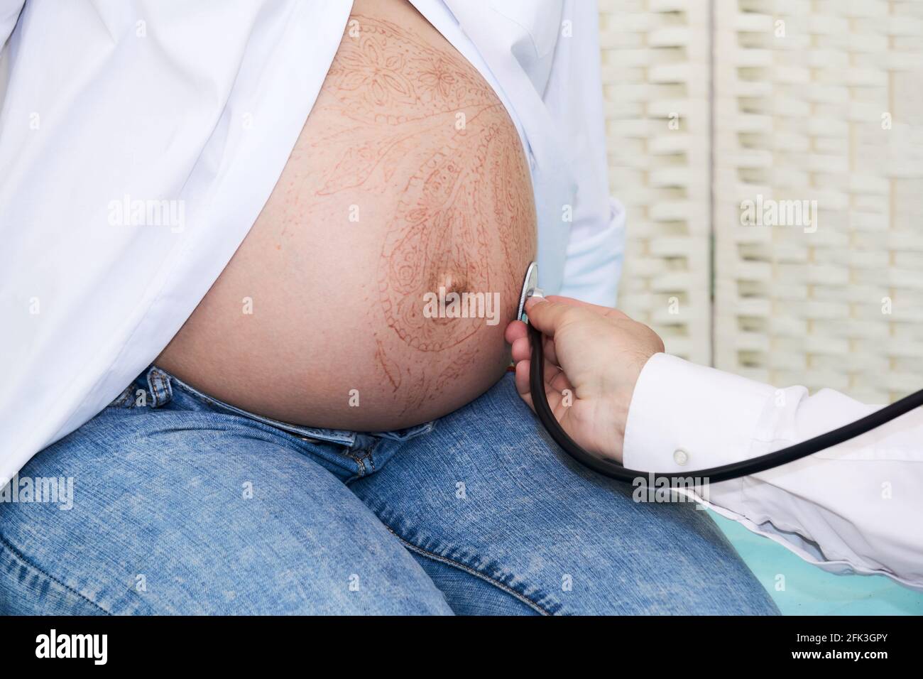 le médecin examine une femme enceinte en écoutant le fœtus ...