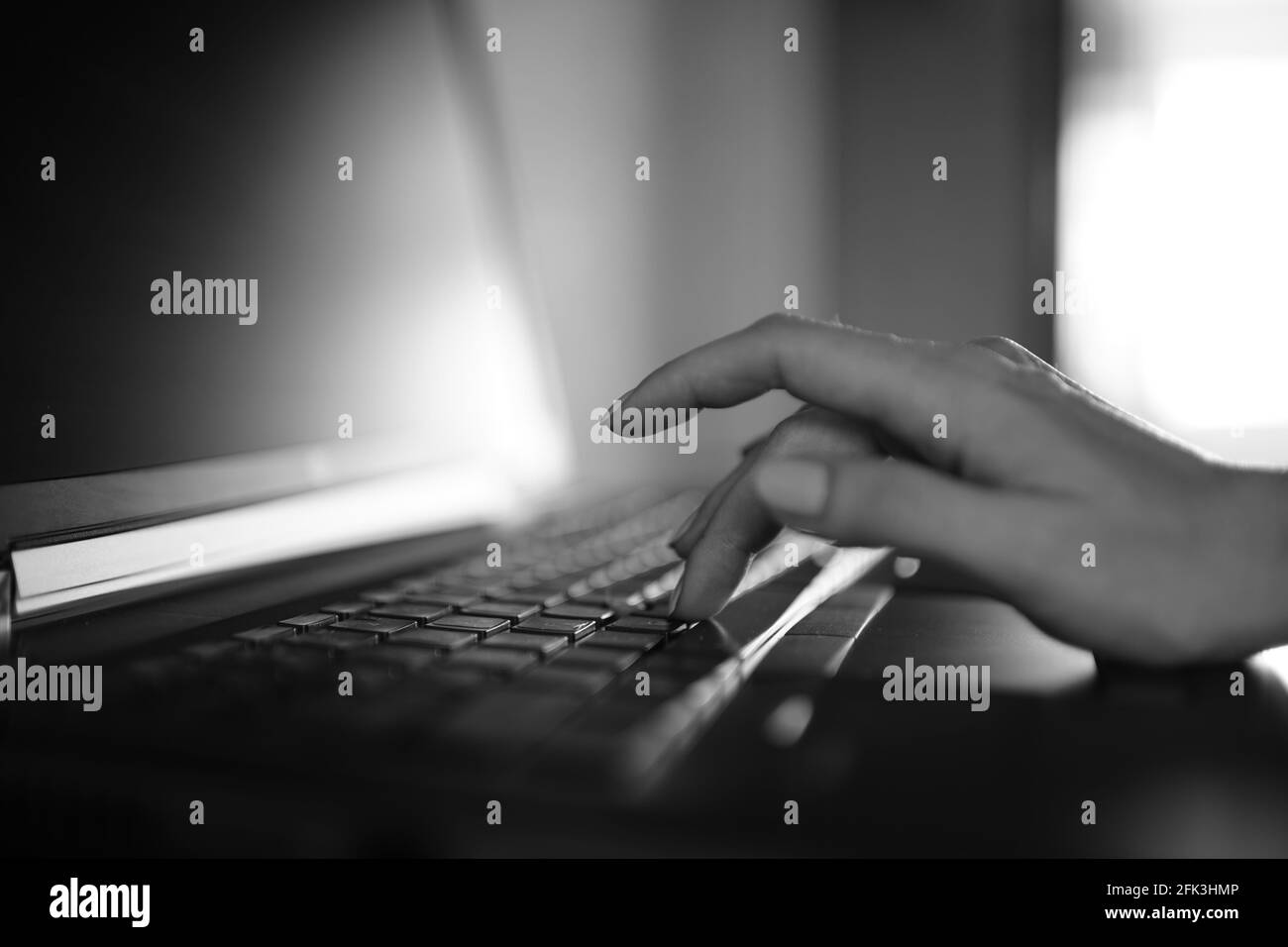Femme dactylographiant à la main sur un clavier d'ordinateur portable. Photo noir et blanc. Banque D'Images