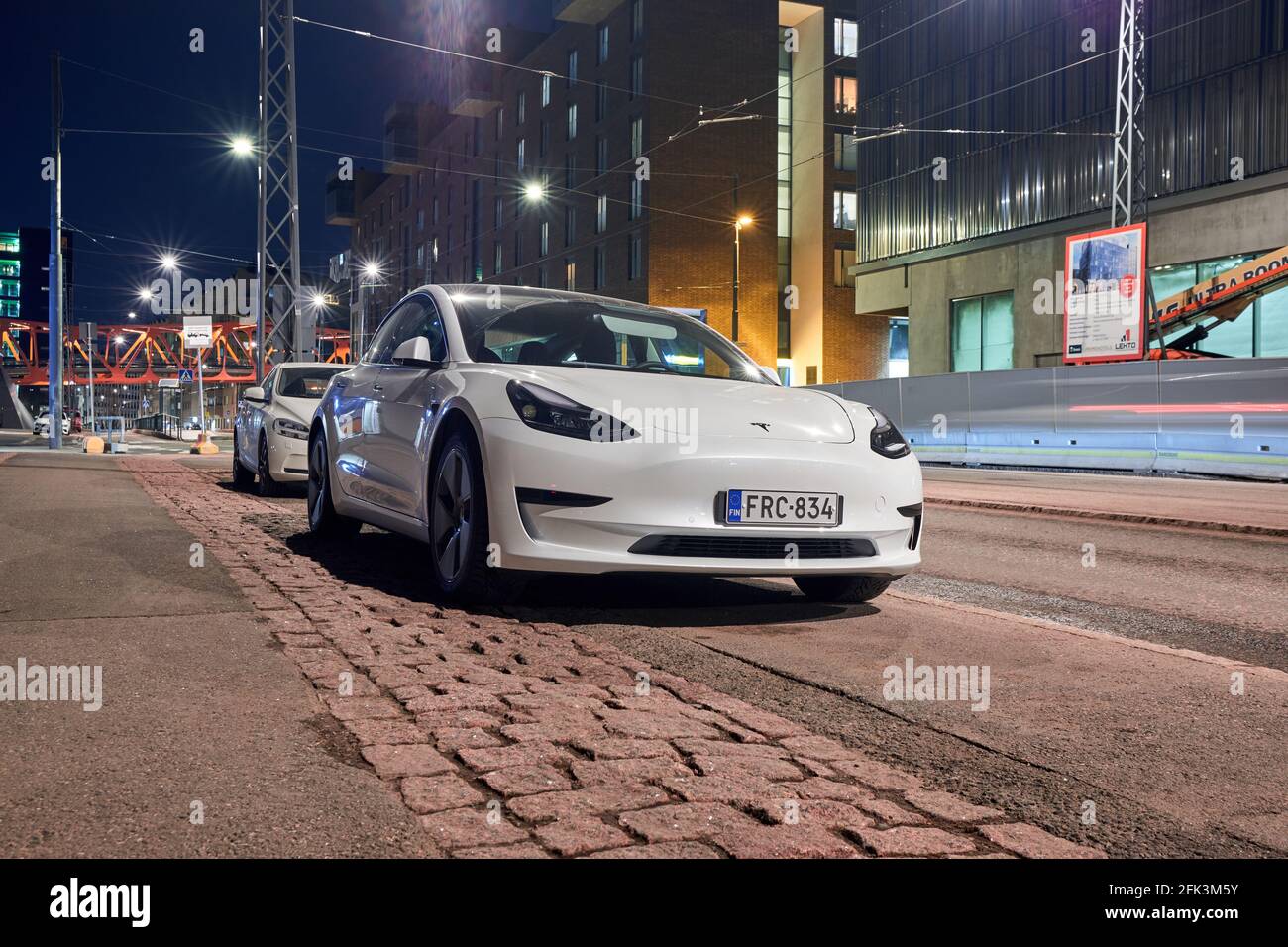 Finlande, Helsinki - 20 avril 2021 : le modèle 3 de Tesla de couleur blanche dans la rue de Jatkasaari, dans le quartier d'Helsinki. Banque D'Images