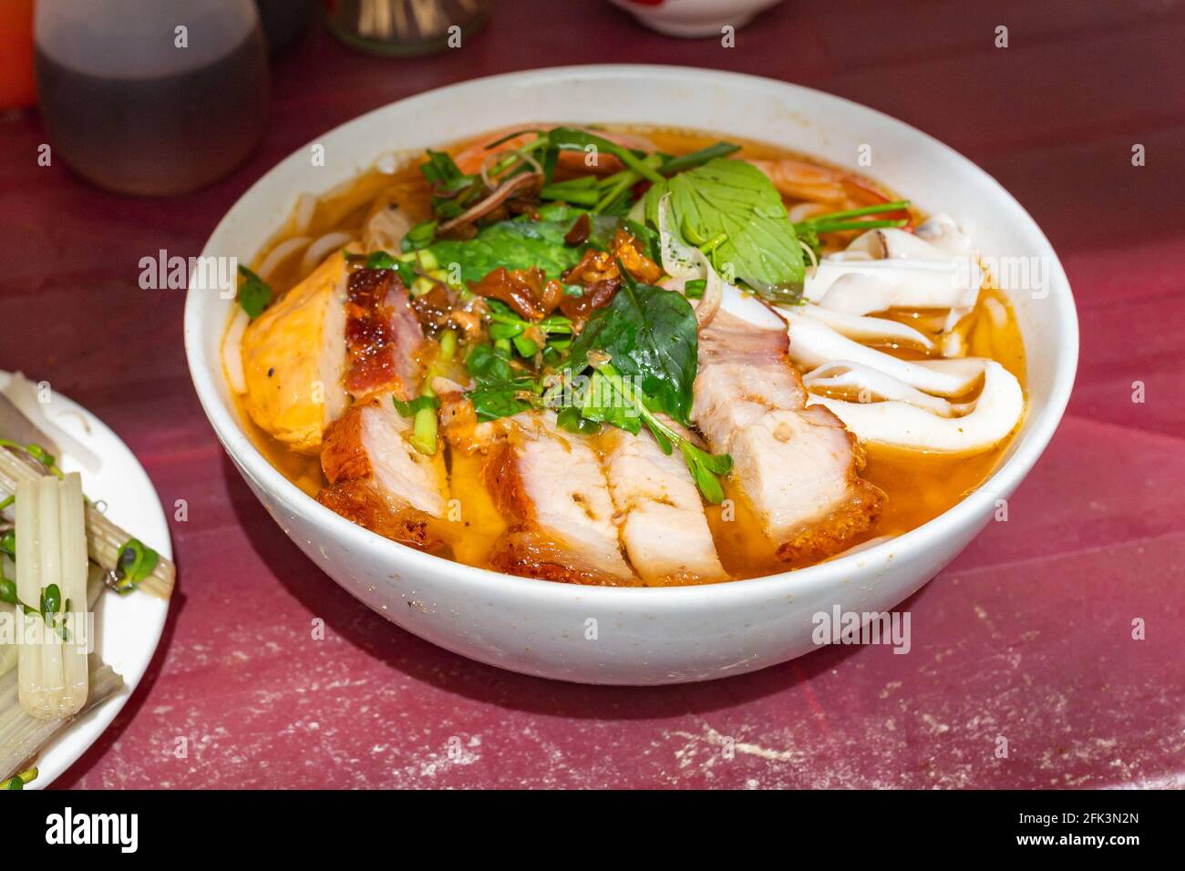 Bol de poisson du Vietnam, nouilles de fruits de mer servies avec torréfié porc Banque D'Images