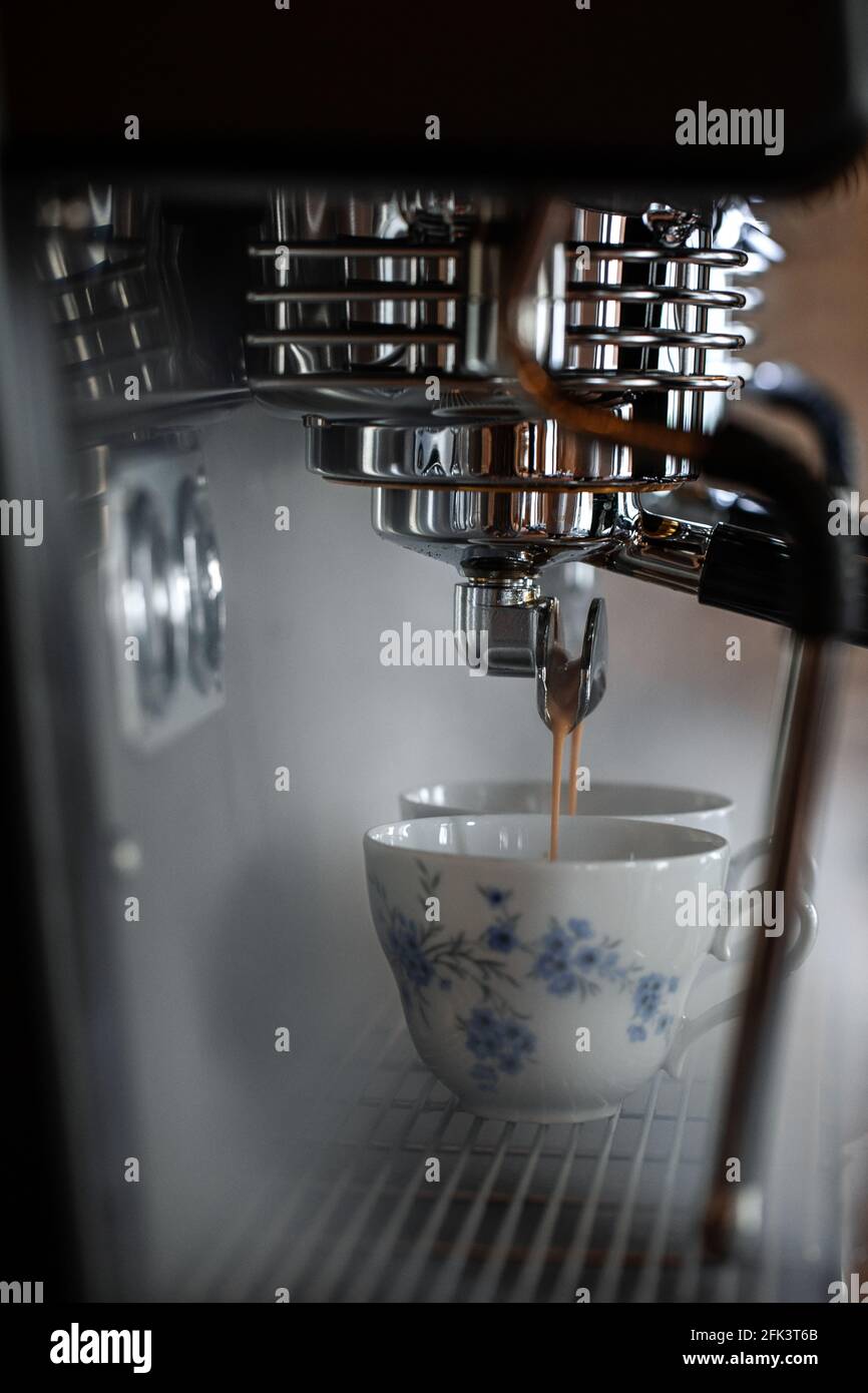 Processus de préparation de l'espresso avec la machine à café. De la vapeur et de magnifiques tasses de style campagnard Banque D'Images