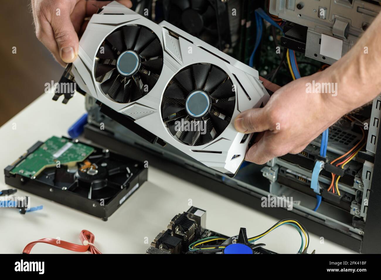 Les mains humaines insèrent une carte vidéo dans un ordinateur. Banque D'Images