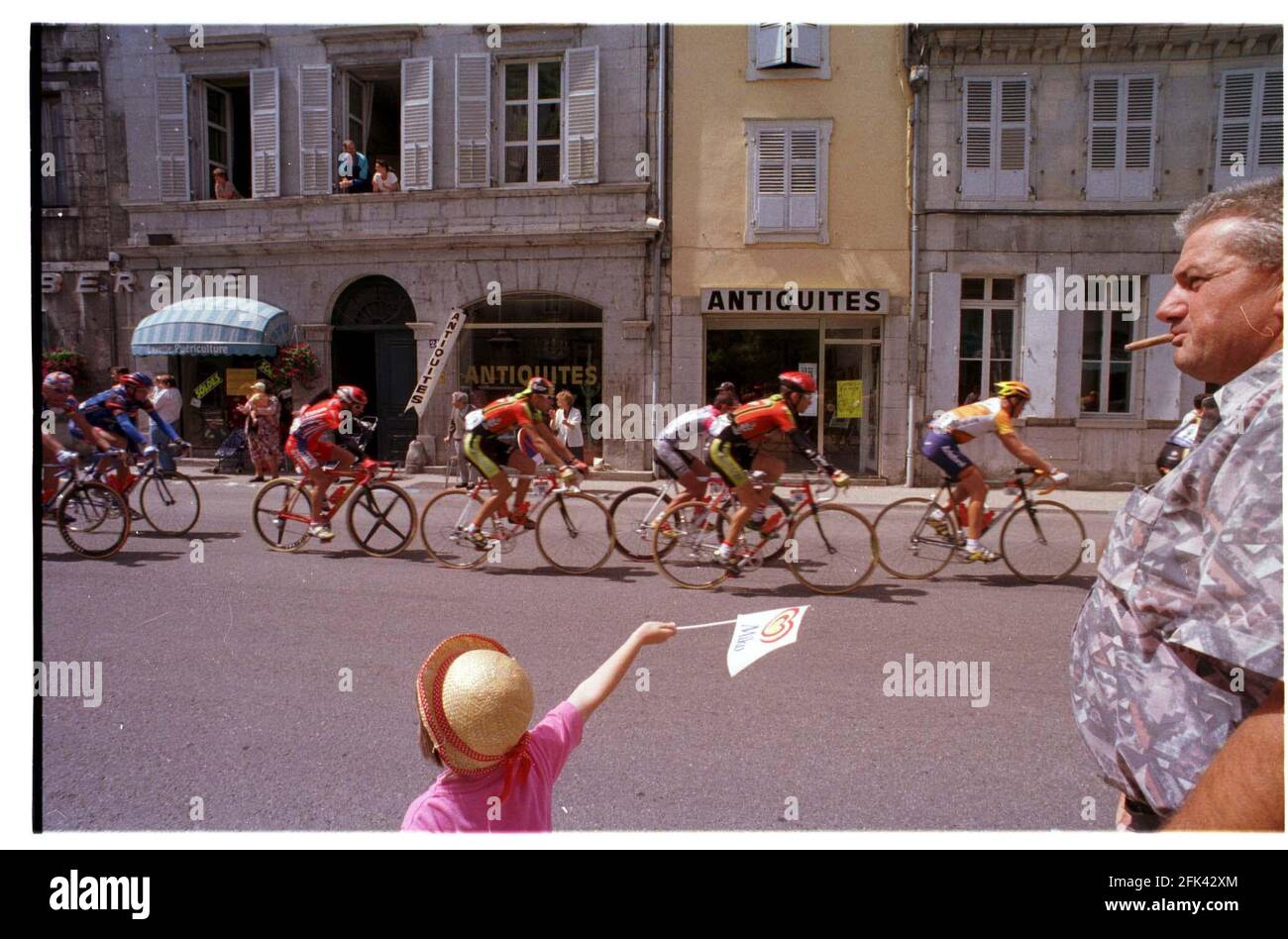 Une petite fille et son grand-père applaudissant les cavaliers dans le Tour de France 1998 course cycliste à travers Salins-les-bains Banque D'Images