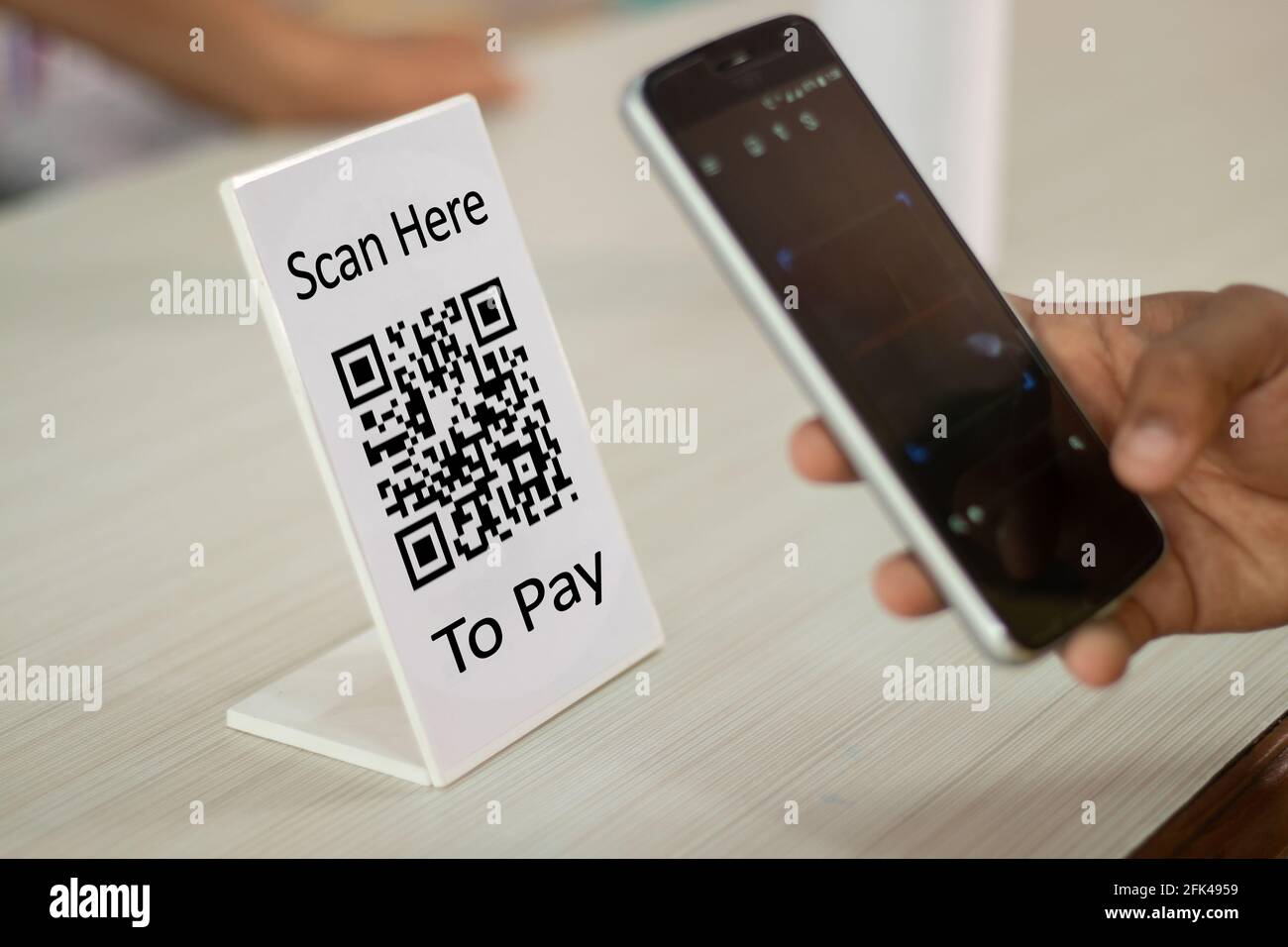 Focus sur scanner ici pour payer du texte, gros plan des mains Scaning QR code pour le contact numérique moins de paiement après achat - concept de technologie, de sécurité et Banque D'Images