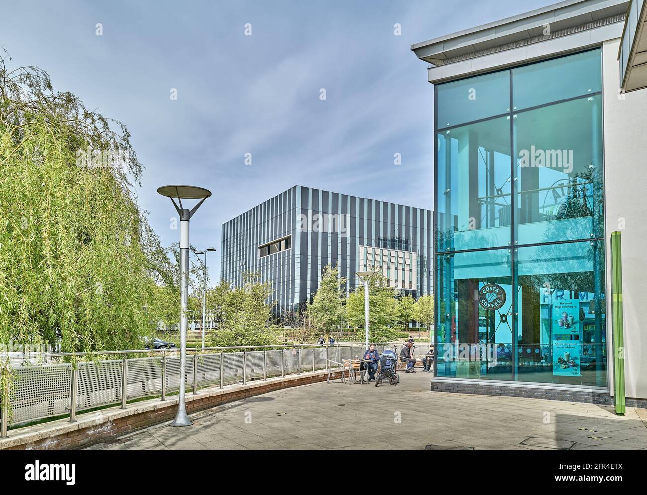 Les amateurs de shopping se détendent devant le café Costa, avec le Cube en arrière-plan, au centre commercial de Corby, dans le Northamptonshire, en Angleterre. Banque D'Images