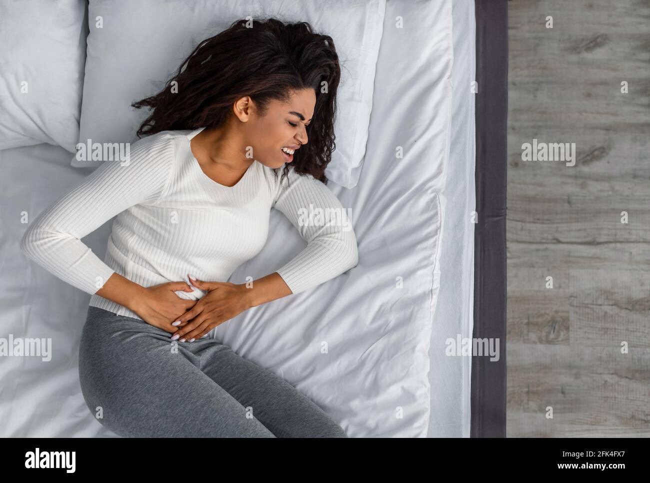 Femme noire souffrant de maux d'estomac, touchant son ventre Banque D'Images