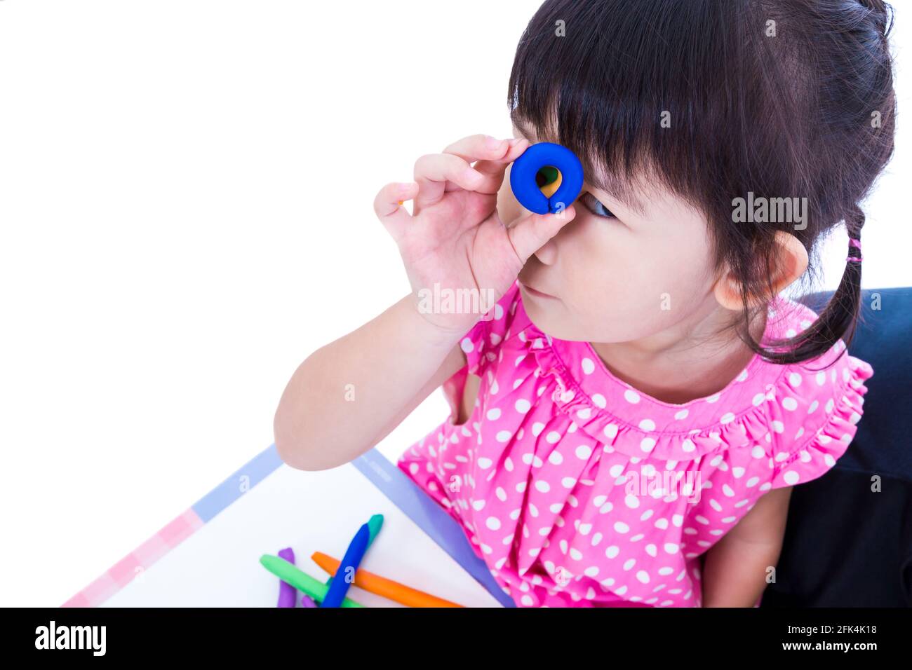 Petite fille asiatique jouant et créant des jouets à partir de la pâte de jeu. Enfant montrer ses œuvres de l'argile, sur fond blanc. Renforcer l'imagination du chil Banque D'Images